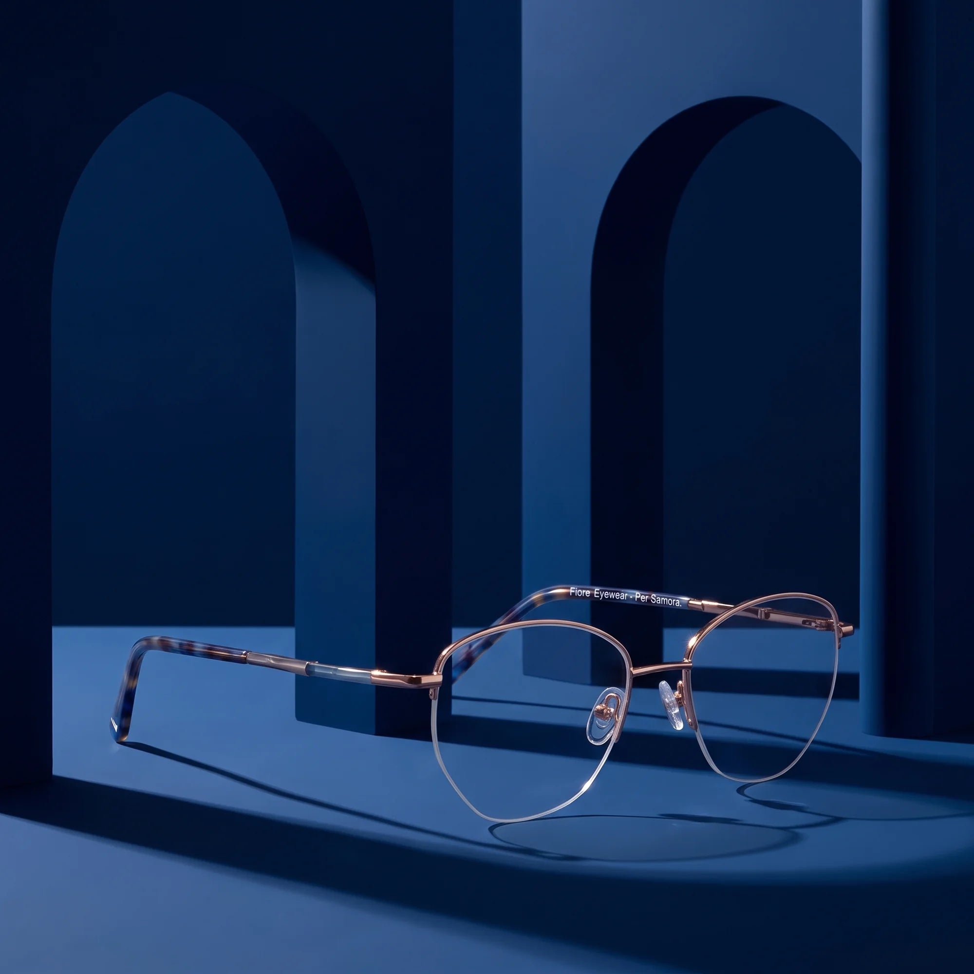Fiore 3921 eyeglasses in grey brown – displayed on a midnight blue podium among arches