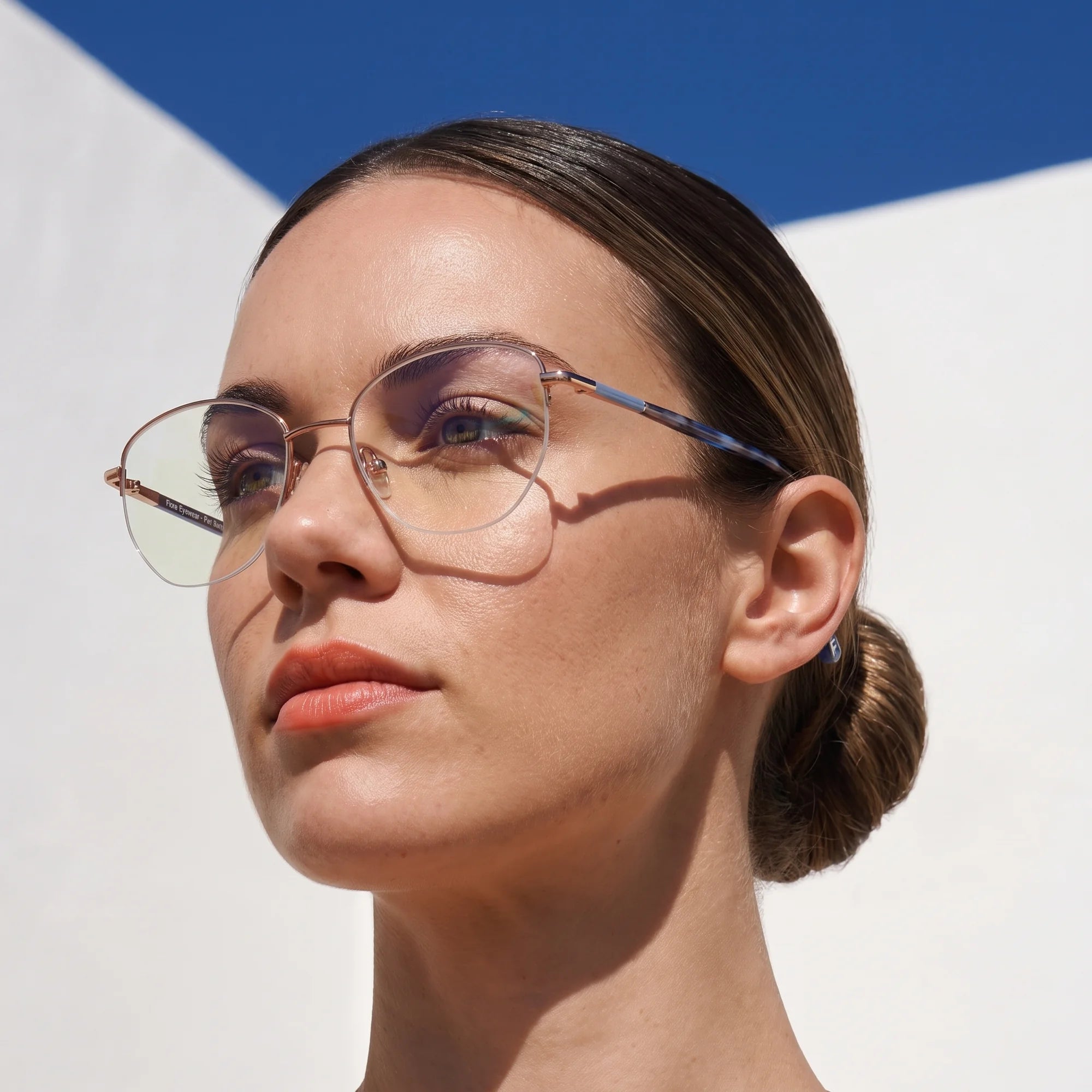 Fiore 3921 eyeglasses in grey brown, worn by a model – campaign portrait, sunlit Balearic whitewash and deep blue sky