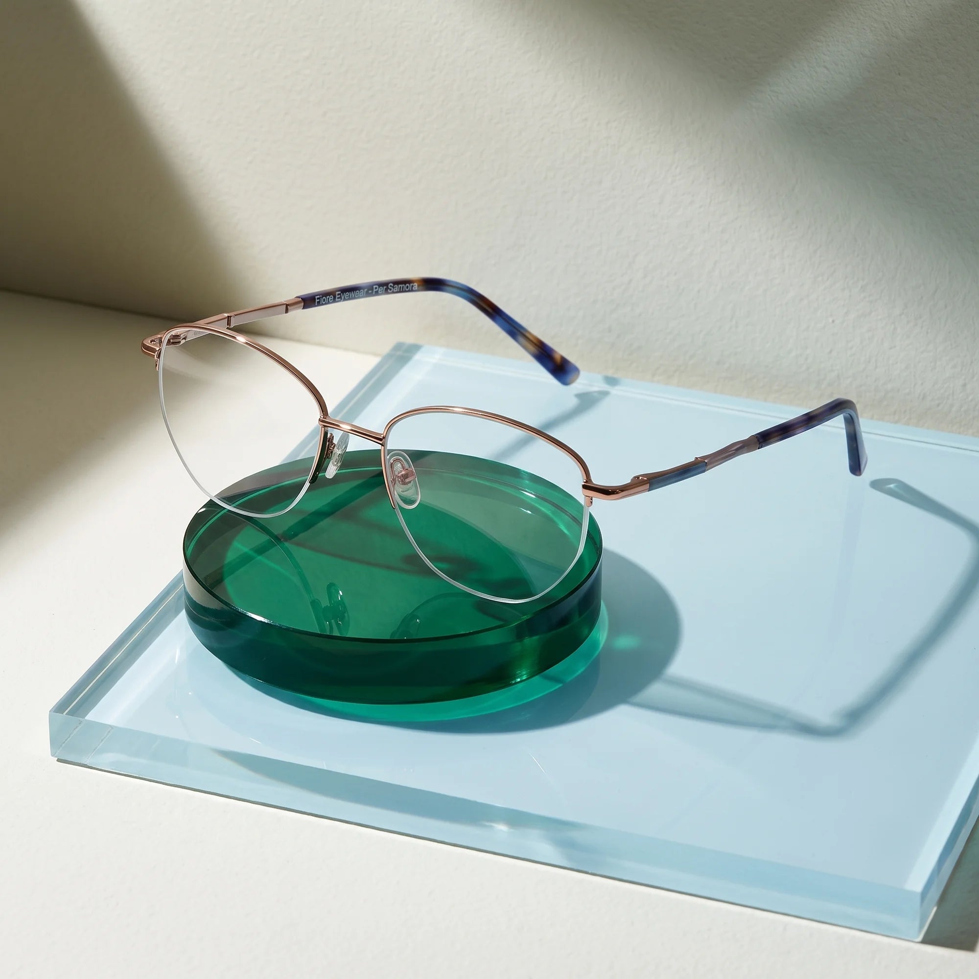 Fiore 3921 eyeglasses in grey brown – on a cobalt acrylic disc in soft daylight