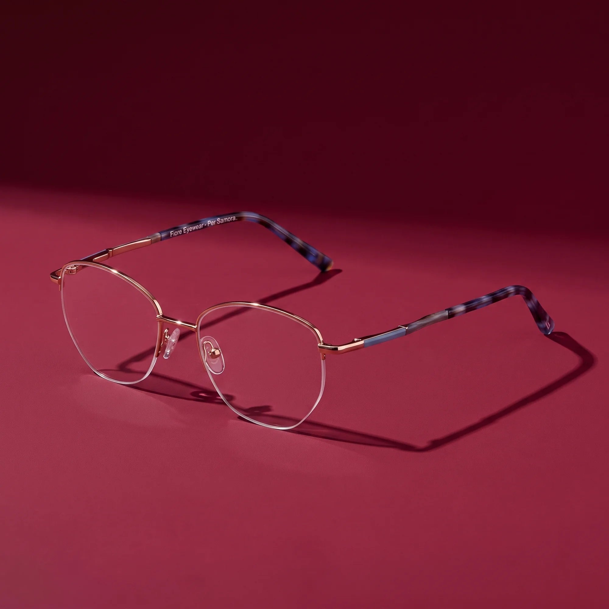 Fiore 3921 eyeglasses in grey brown – editorial still life on a saturated burgundy set
