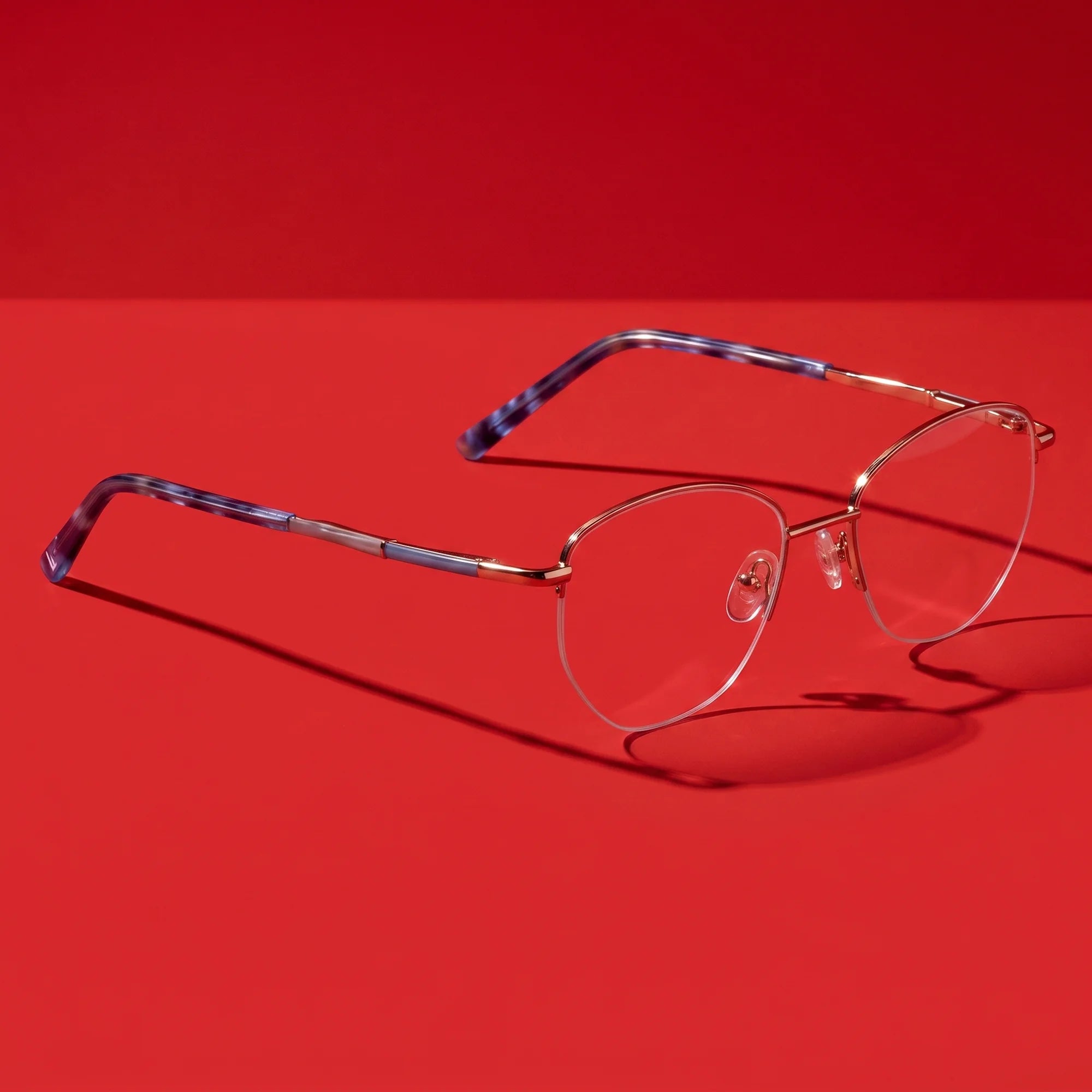 Fiore 3921 eyeglasses in grey brown – hero still life against a deep vivid red backdrop