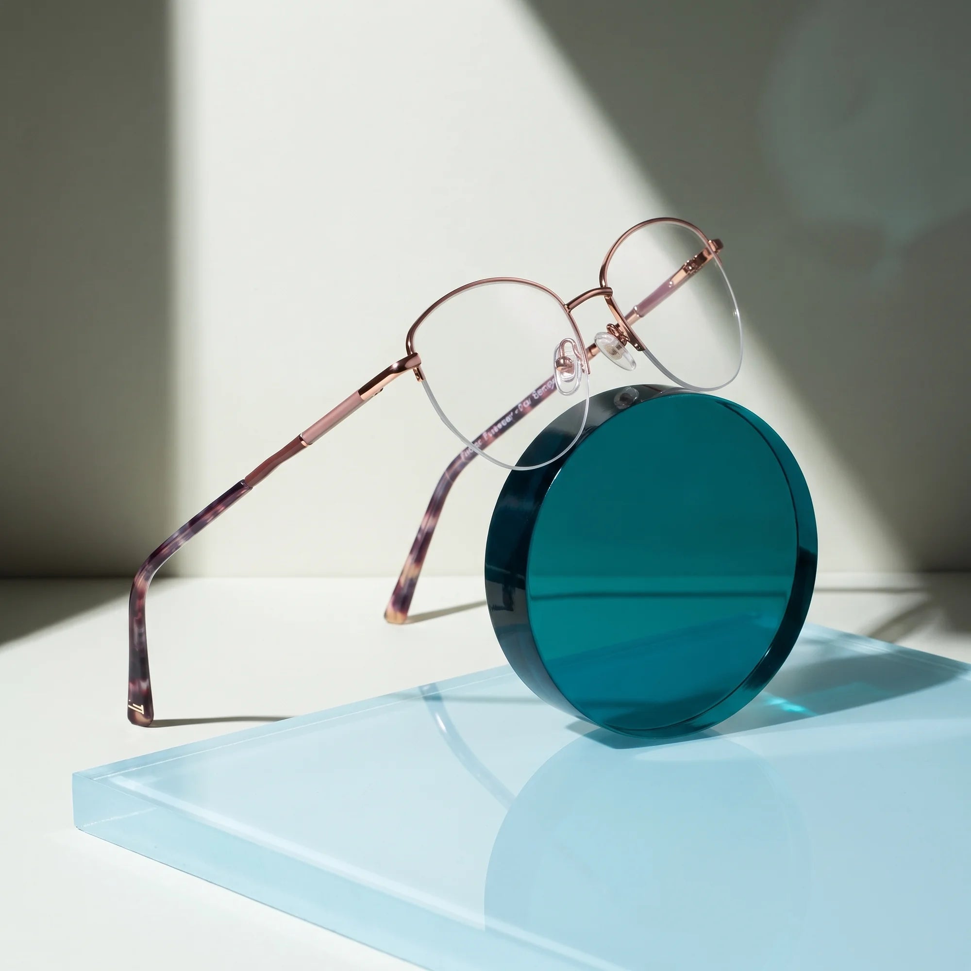 Fiore 3921 eyeglasses in brown gold – on a cobalt acrylic disc in soft daylight