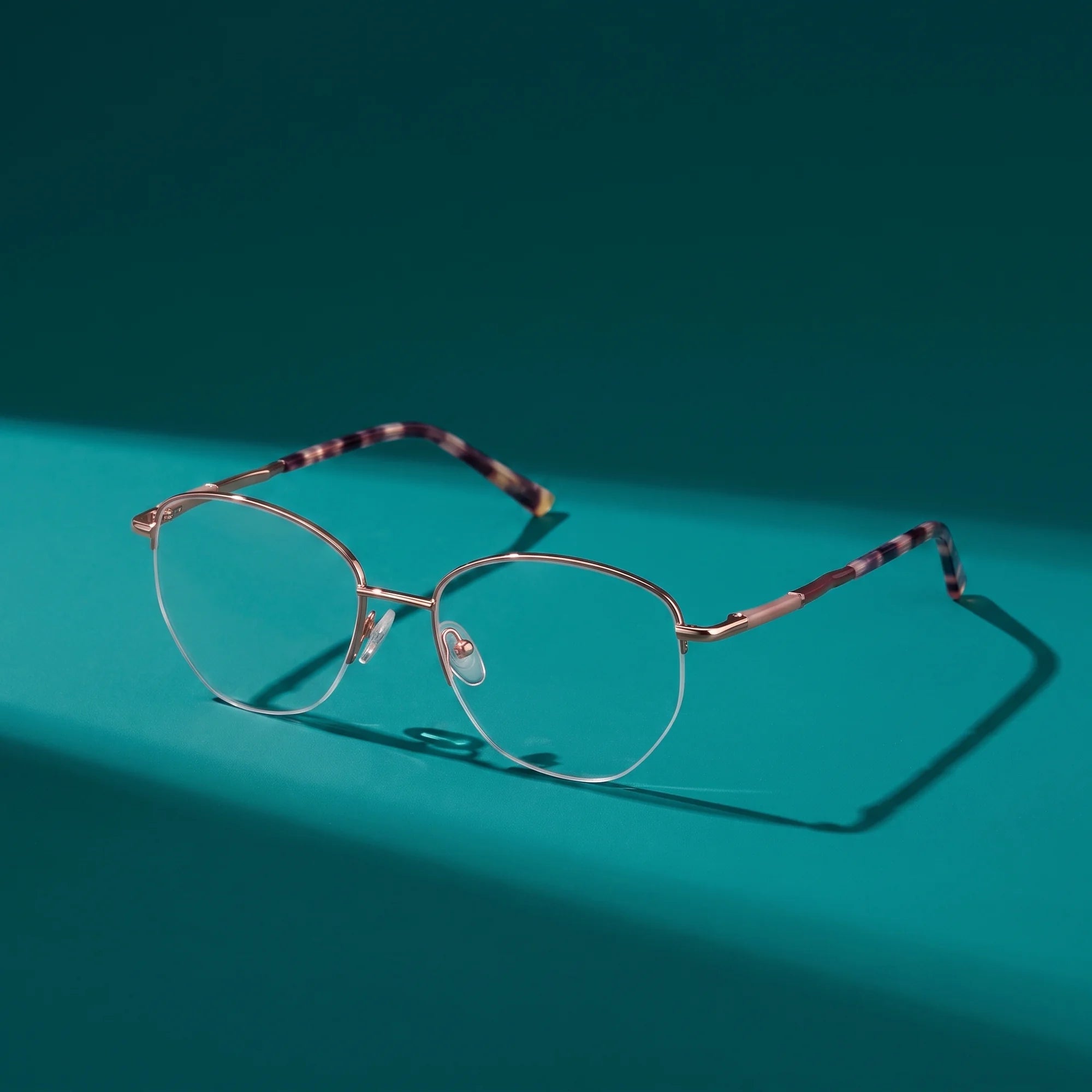 Fiore 3921 eyeglasses in brown gold – still life on a seamless teal studio backdrop