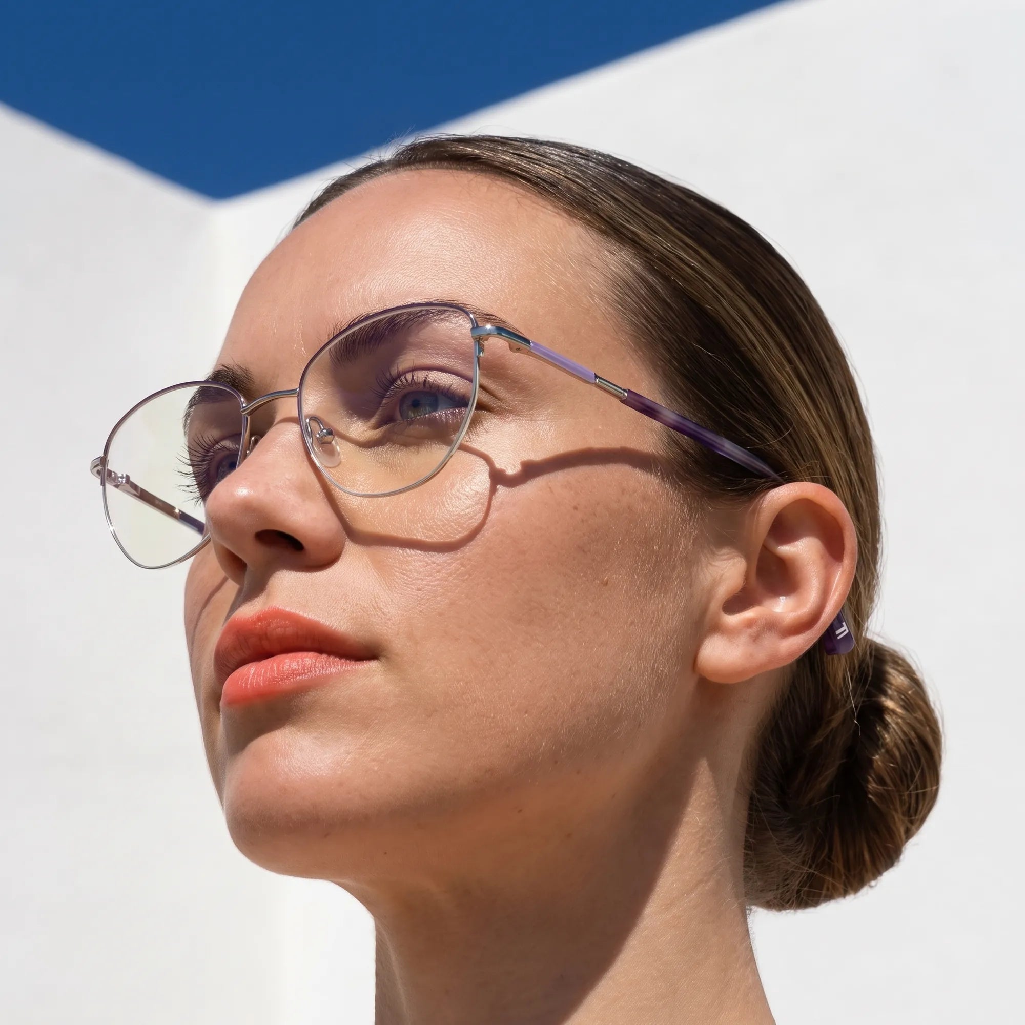 Fiore 3921 eyeglasses in purple silver, worn by a model – campaign portrait, sunlit Balearic whitewash and deep blue sky