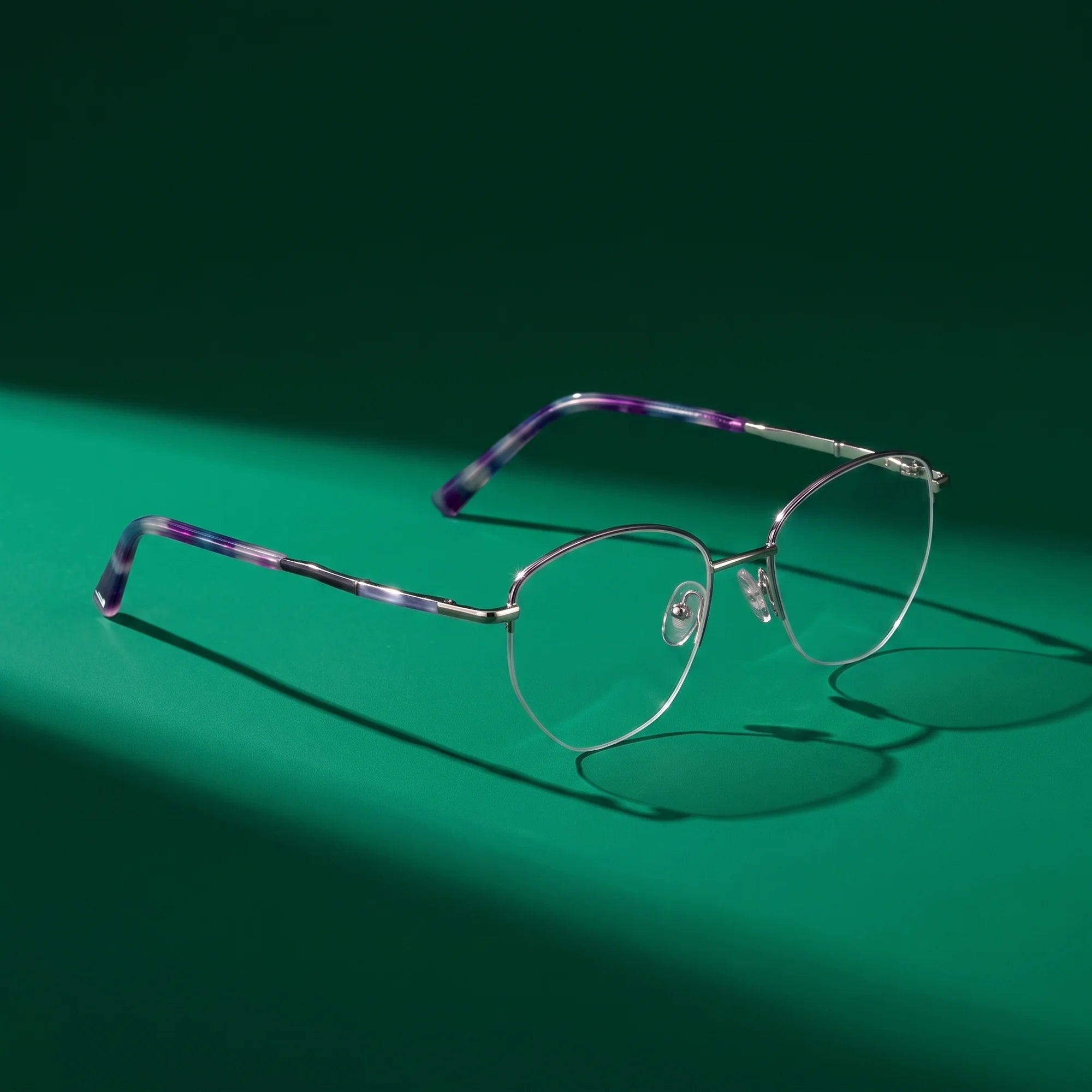 Fiore 3921 eyeglasses in purple silver – still life on a seamless emerald studio backdrop