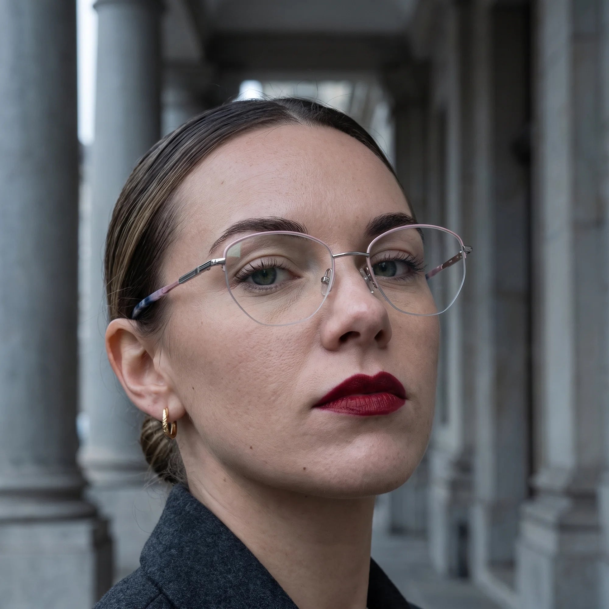 Fiore 3921 eyeglasses in pink silver, worn by a model – campaign portrait, moody autumn portrait between stone columns