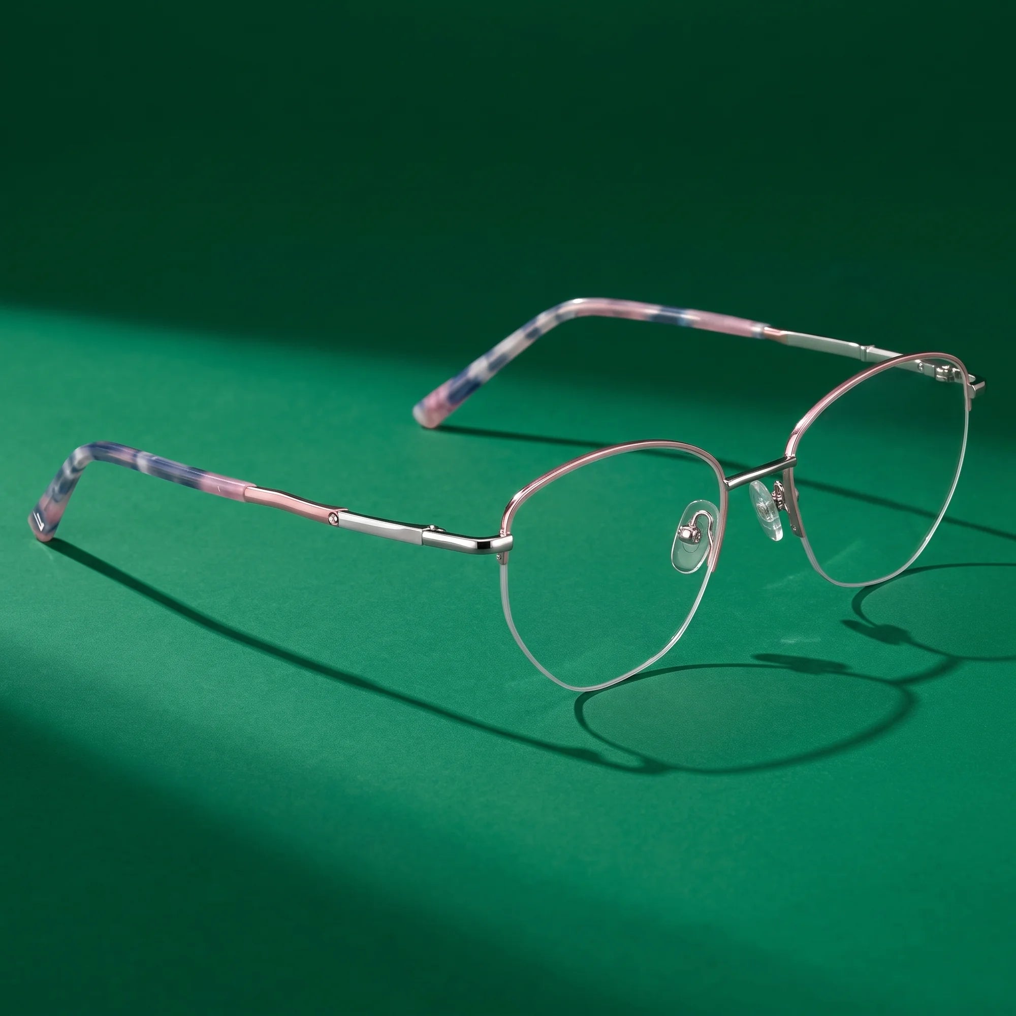 Fiore 3921 eyeglasses in pink silver – editorial still life on a saturated emerald set