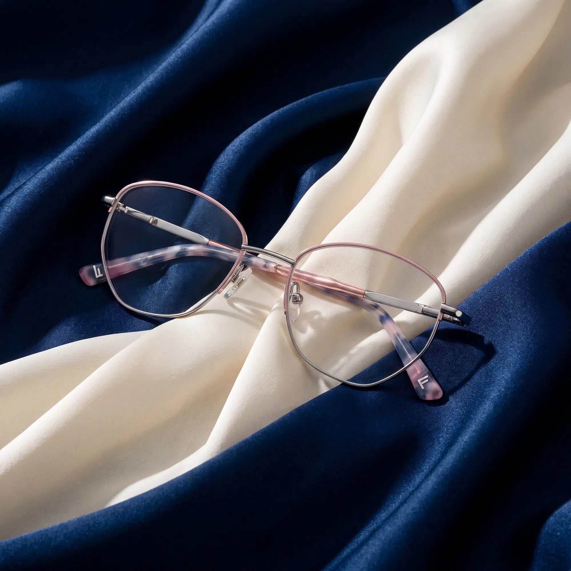 Fiore 3921 eyeglasses in pink silver – resting on draped midnight blue and ivory silk