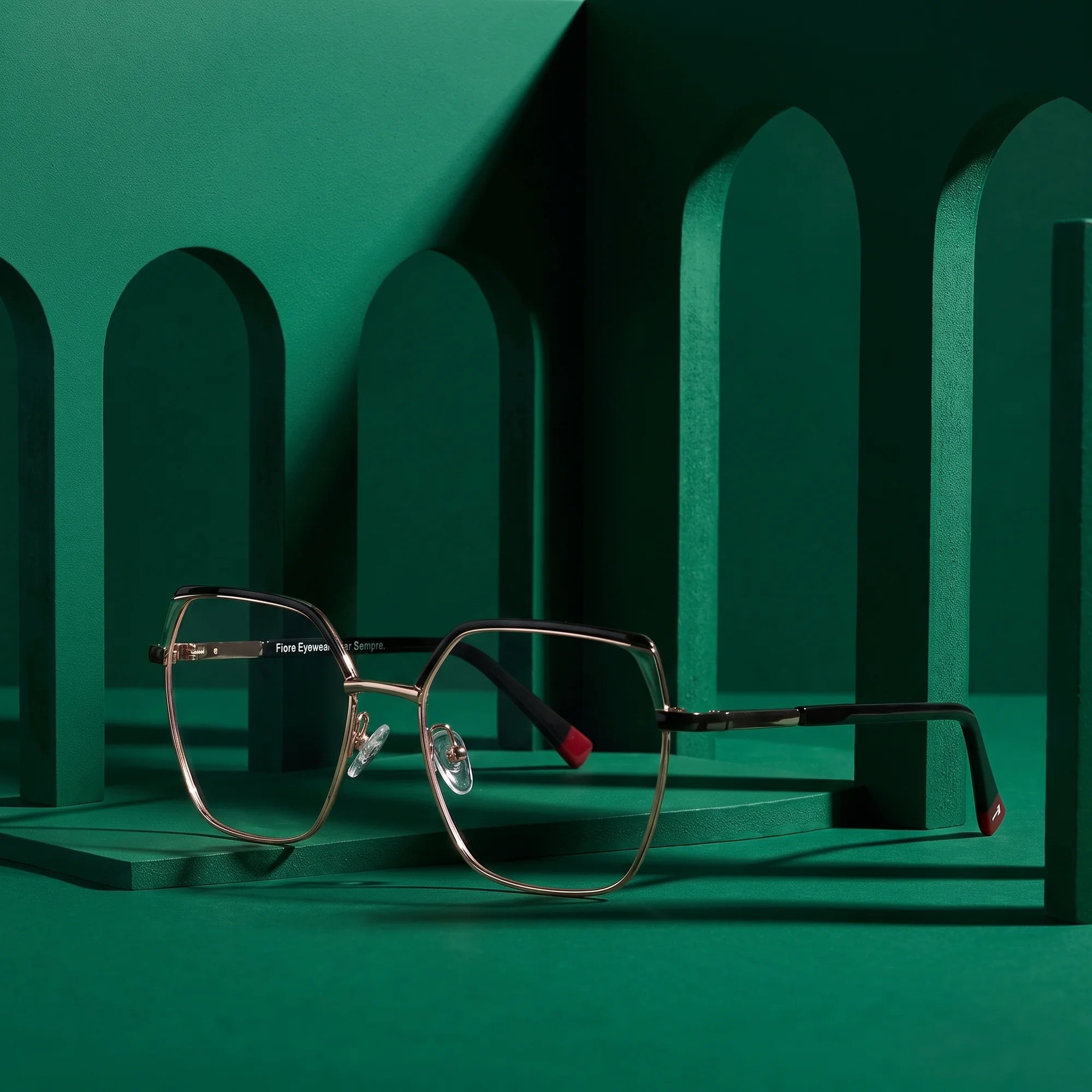 Fiore 3971 eyeglasses in black gold – staged on a sculptural emerald architecture set