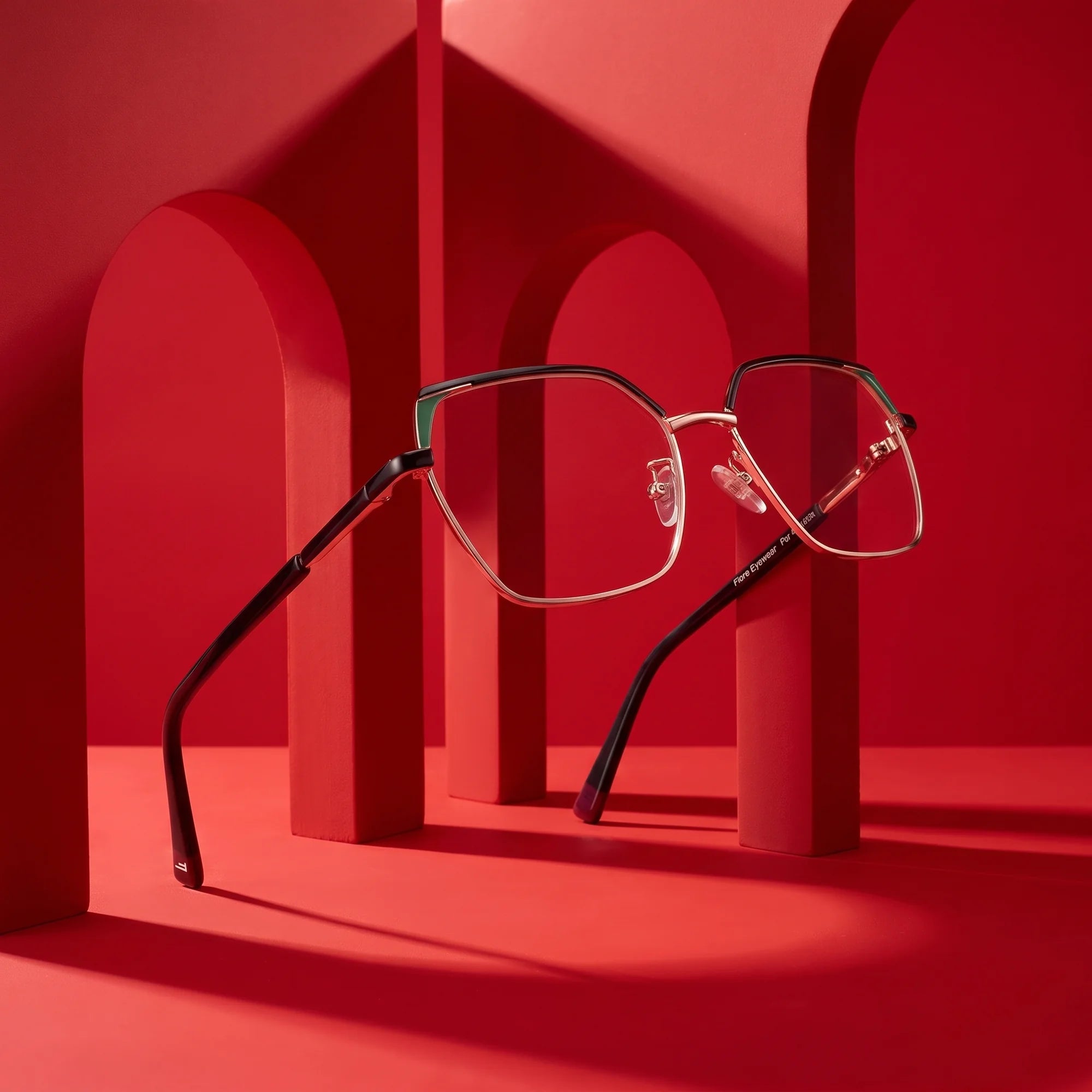 Fiore 3971 eyeglasses in black gold – displayed on a vivid red podium among arches