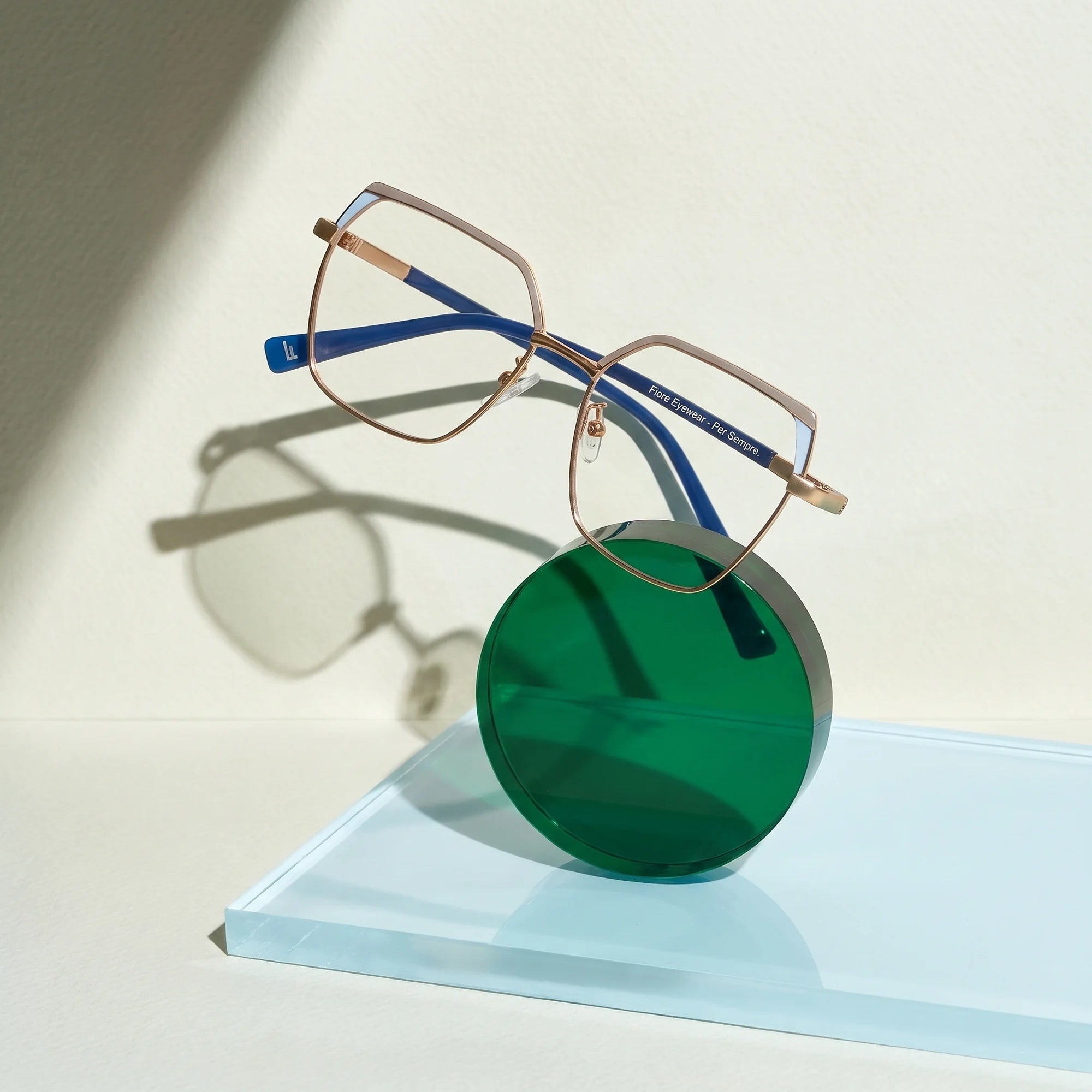 Fiore 3971 eyeglasses in grey gold – on a cobalt acrylic disc in soft daylight