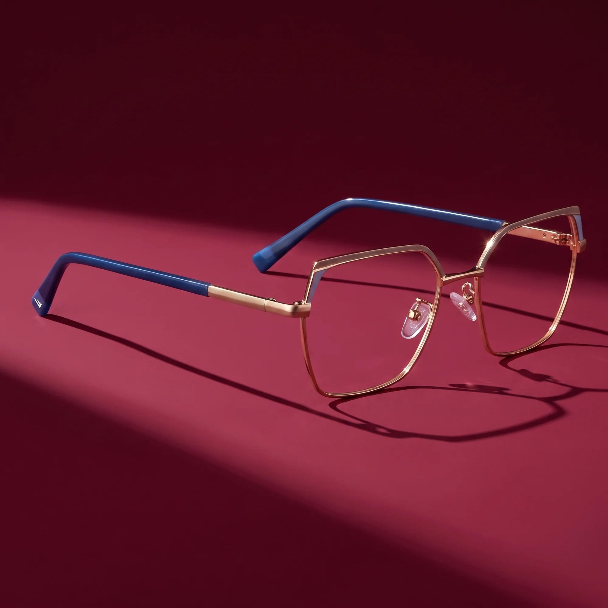 Fiore 3971 eyeglasses in grey gold – editorial still life on a saturated burgundy set