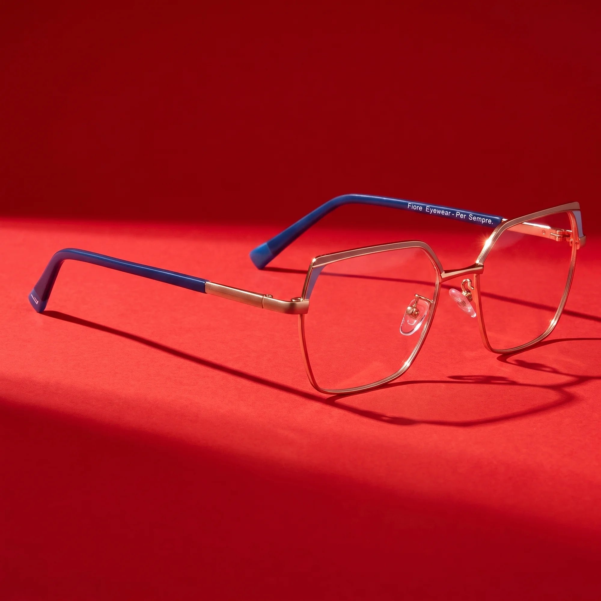 Fiore 3971 eyeglasses in grey gold – hero still life against a deep vivid red backdrop