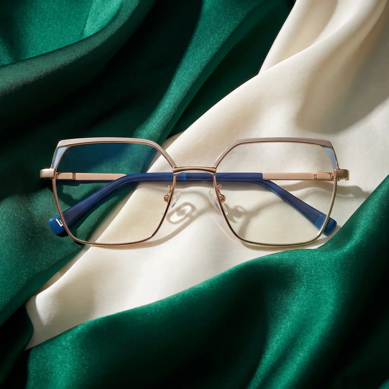 Fiore 3971 eyeglasses in grey gold – resting on draped emerald and ivory silk