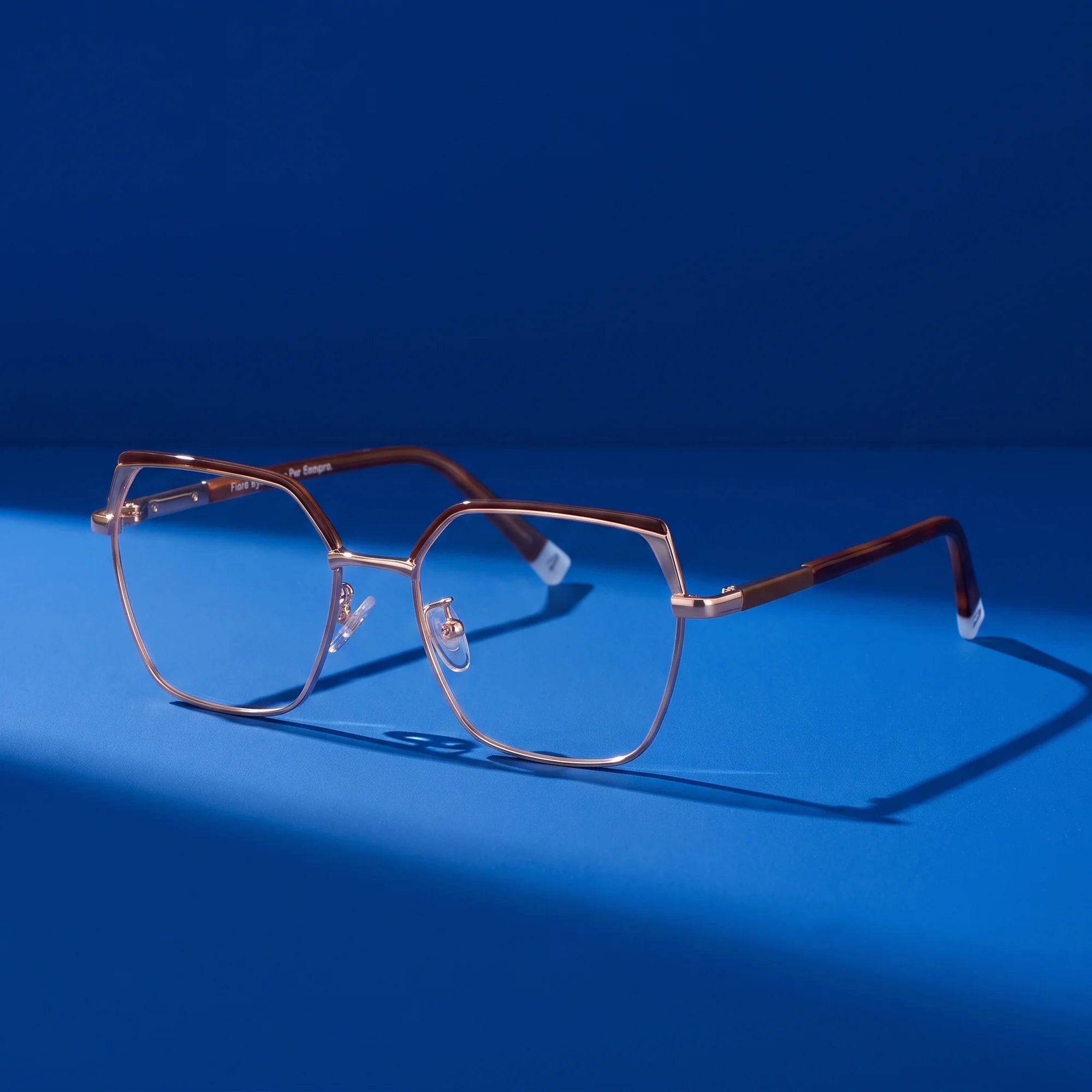 Fiore 3971 eyeglasses in brown gold – still life on a seamless cobalt studio backdrop