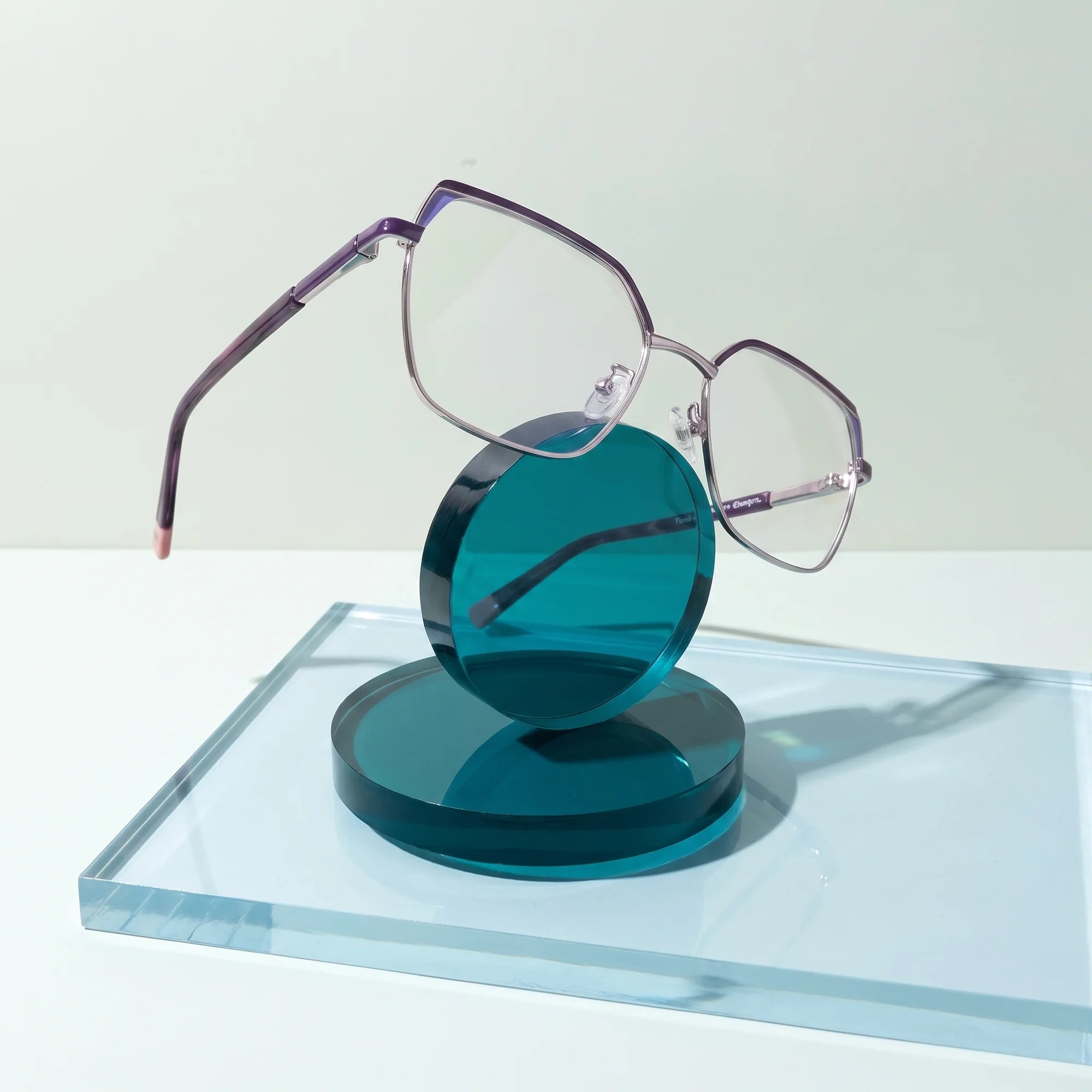 Fiore 3971 eyeglasses in purple silver – on a cobalt acrylic disc in soft daylight