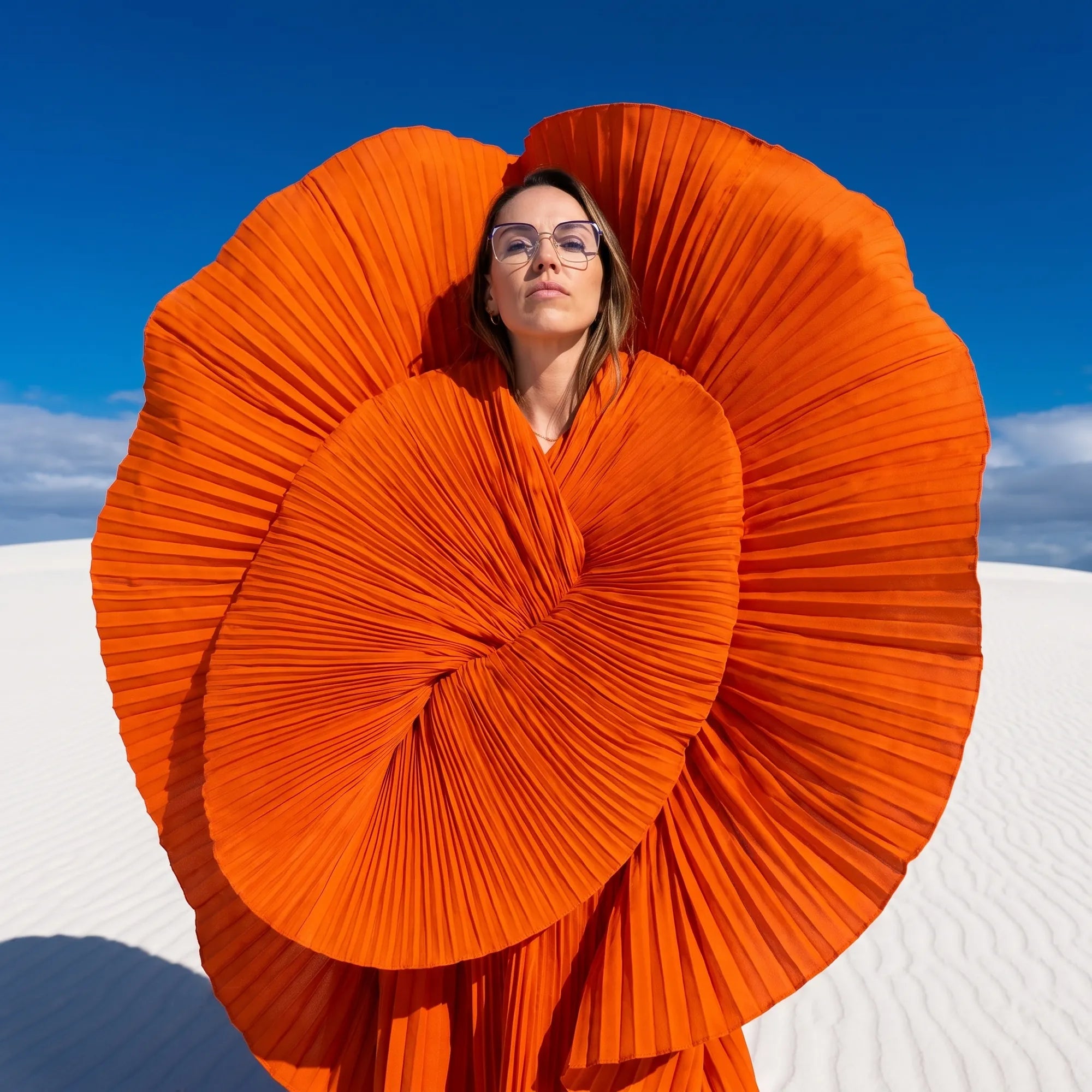 Fiore 3971 eyeglasses in purple silver, worn by a model – campaign portrait, sculptural orange pleated fan on white dunes
