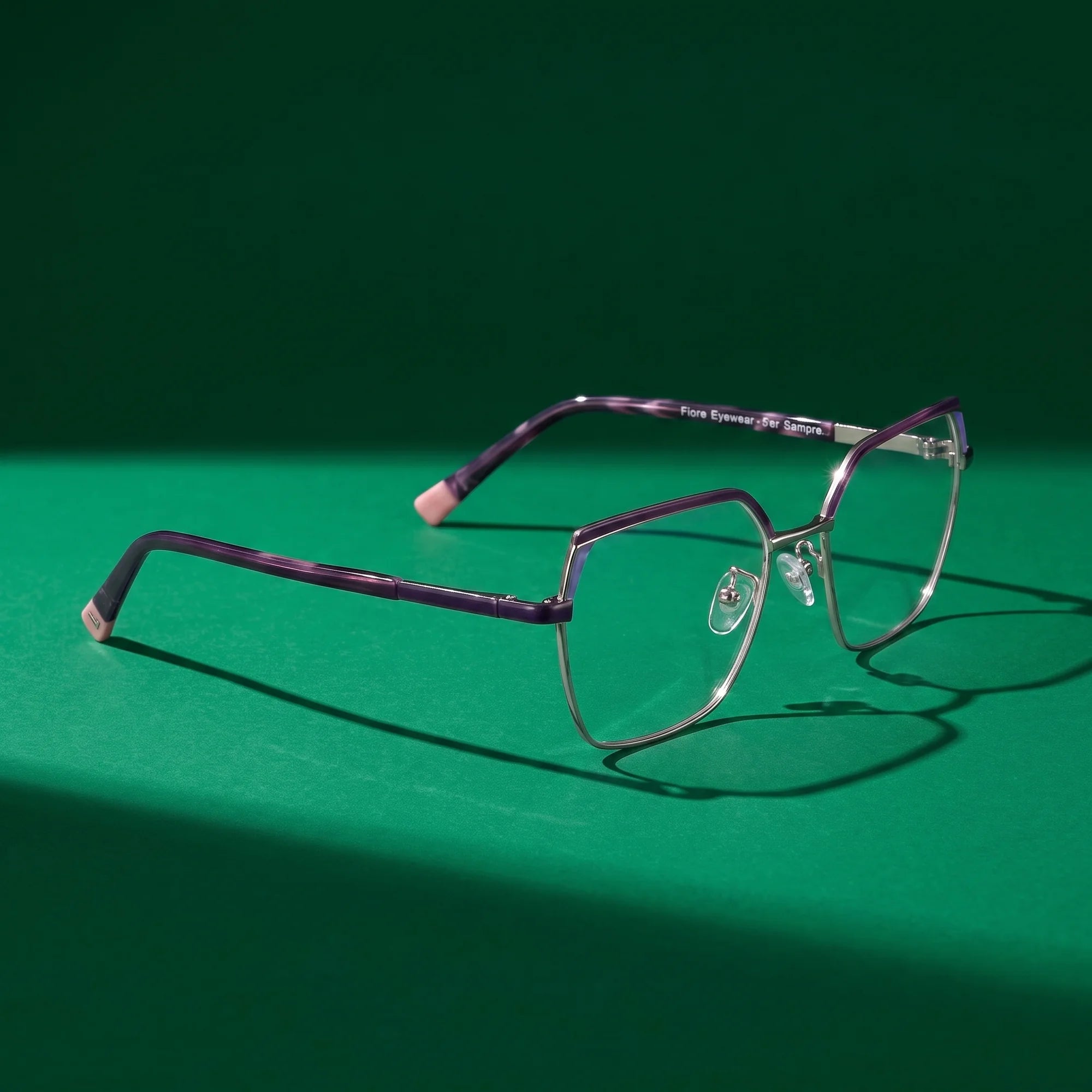 Fiore 3971 eyeglasses in purple silver – editorial still life on a saturated emerald set