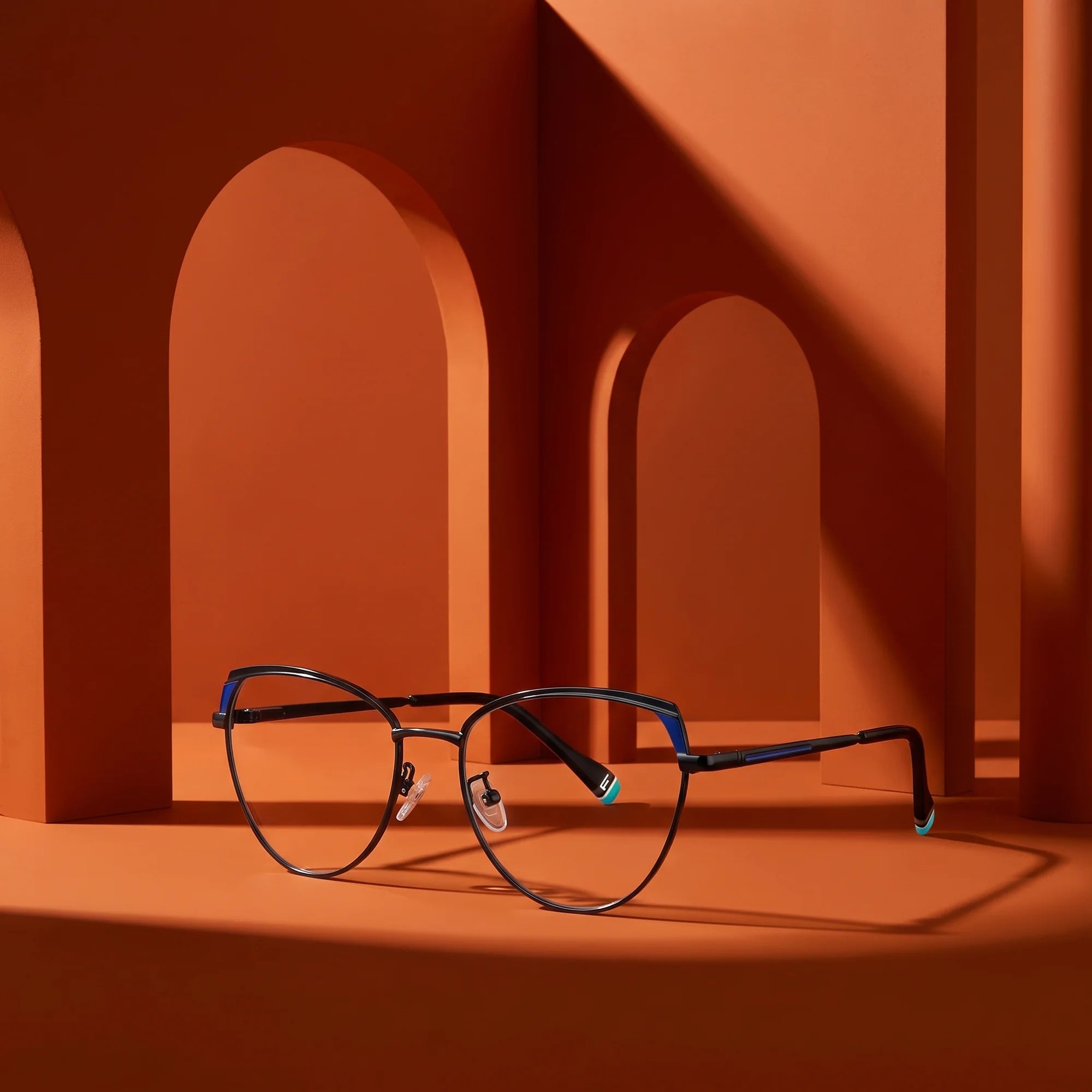 Fiore 3983 eyeglasses in black blue – staged on a sculptural burnt orange architecture set