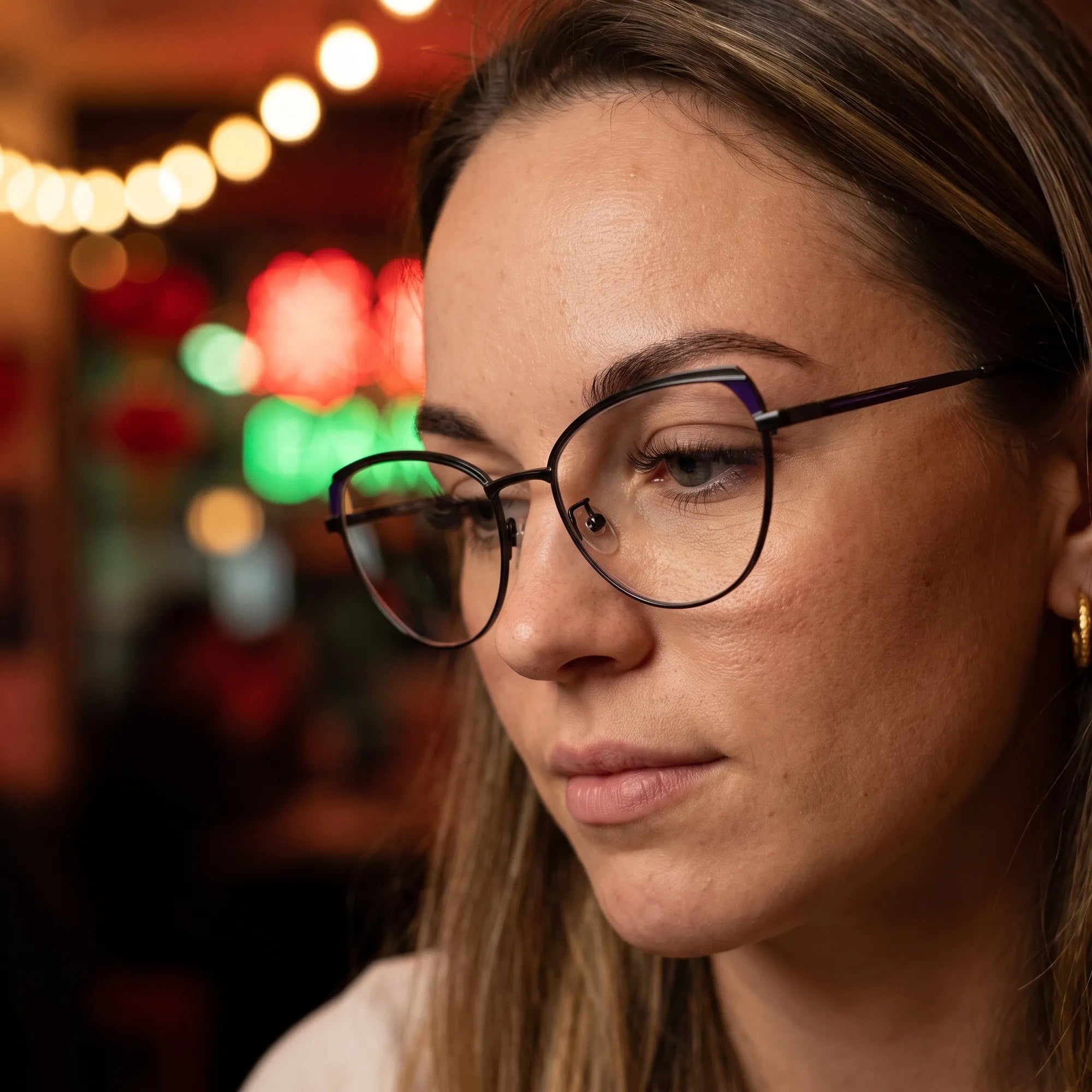Fiore 3983 eyeglasses in black blue, worn by a model – campaign portrait, candid portrait in neon-lit evening glow