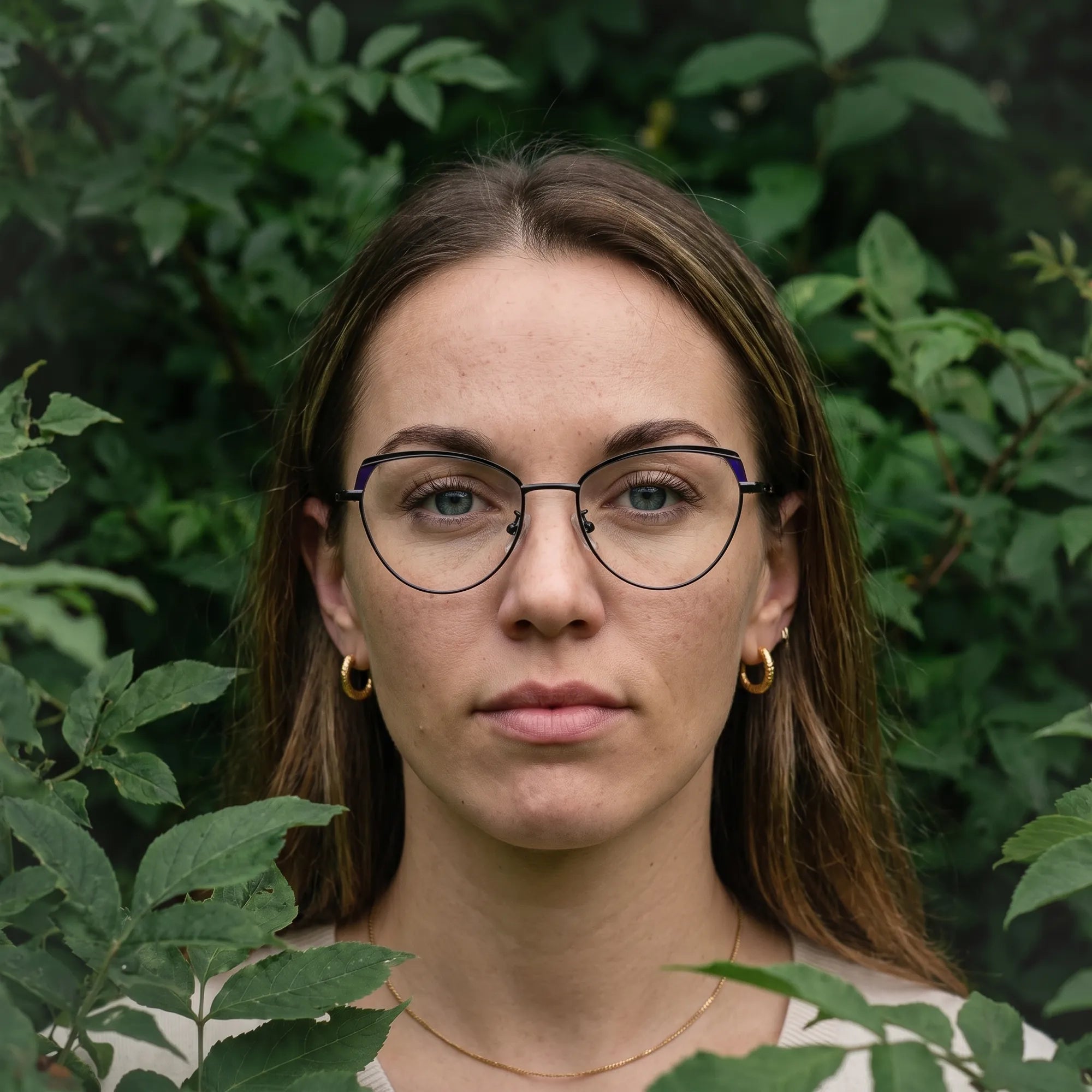 Fiore 3983 eyeglasses in black blue, worn by a model – campaign portrait, summer daydream in a garden armchair