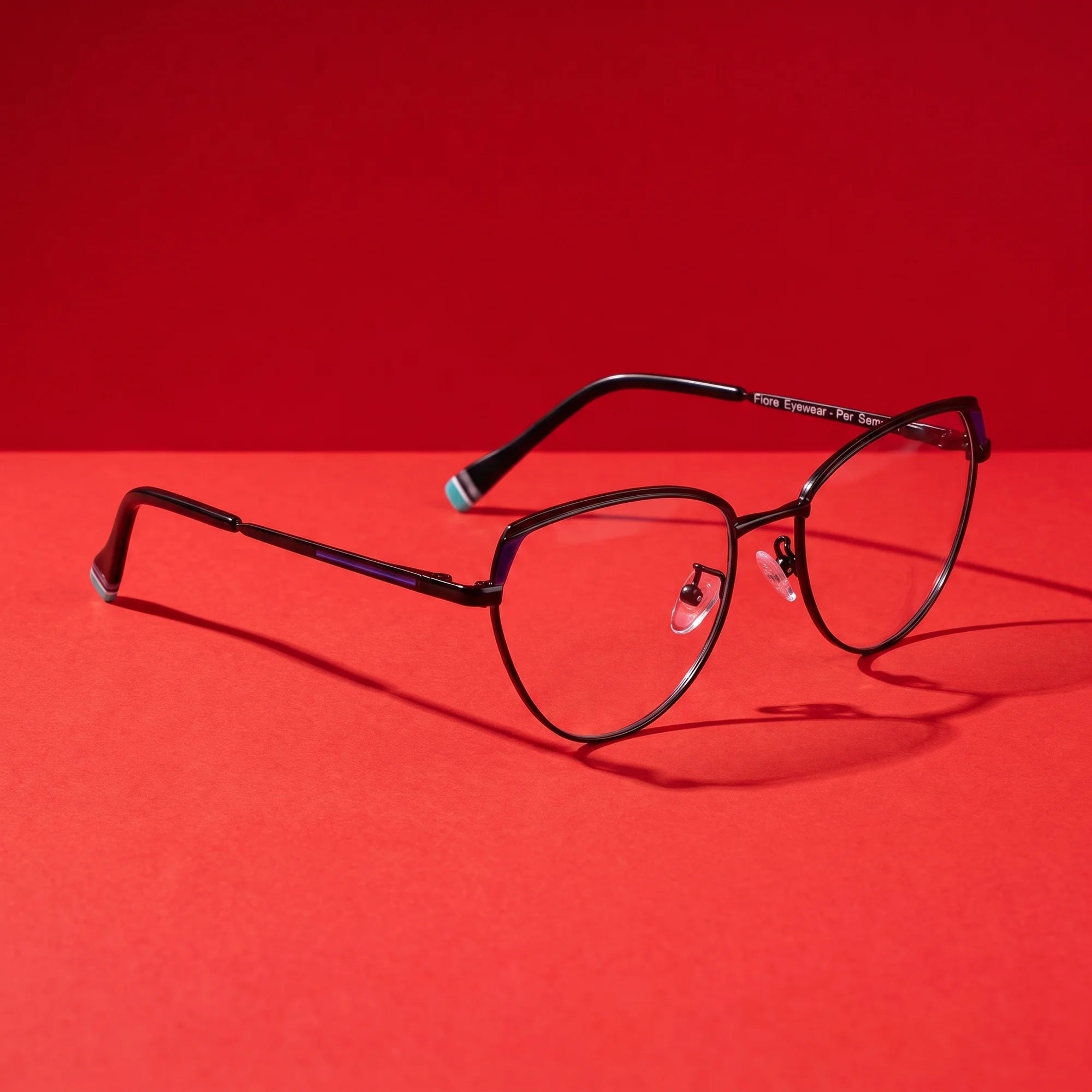 Fiore 3983 eyeglasses in black blue – editorial still life on a saturated vivid red set