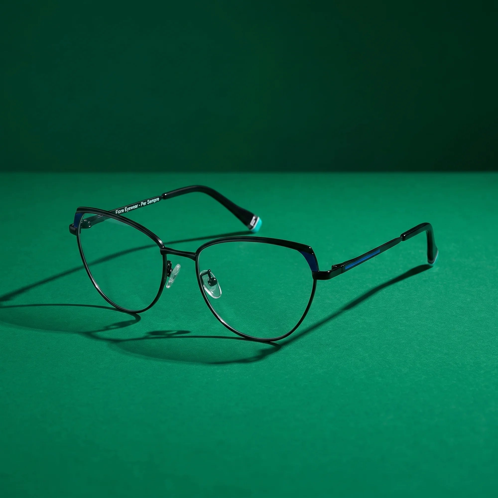 Fiore 3983 eyeglasses in black blue – still life on a seamless emerald studio backdrop