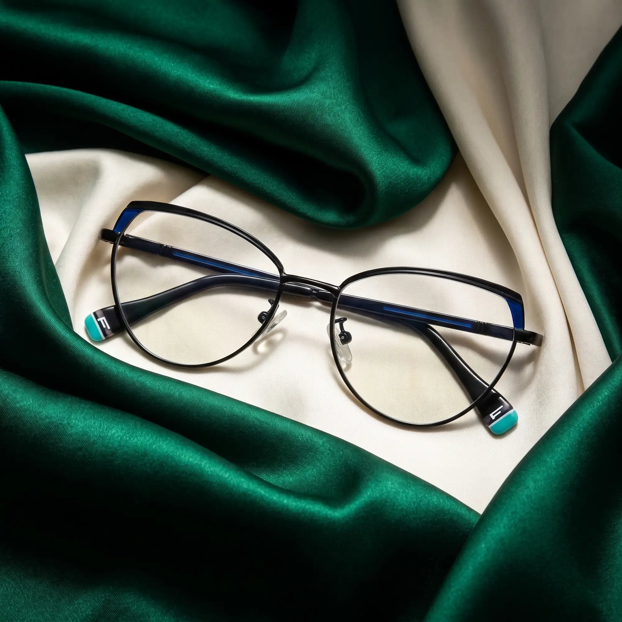 Fiore 3983 eyeglasses in black blue – resting on draped emerald and ivory silk
