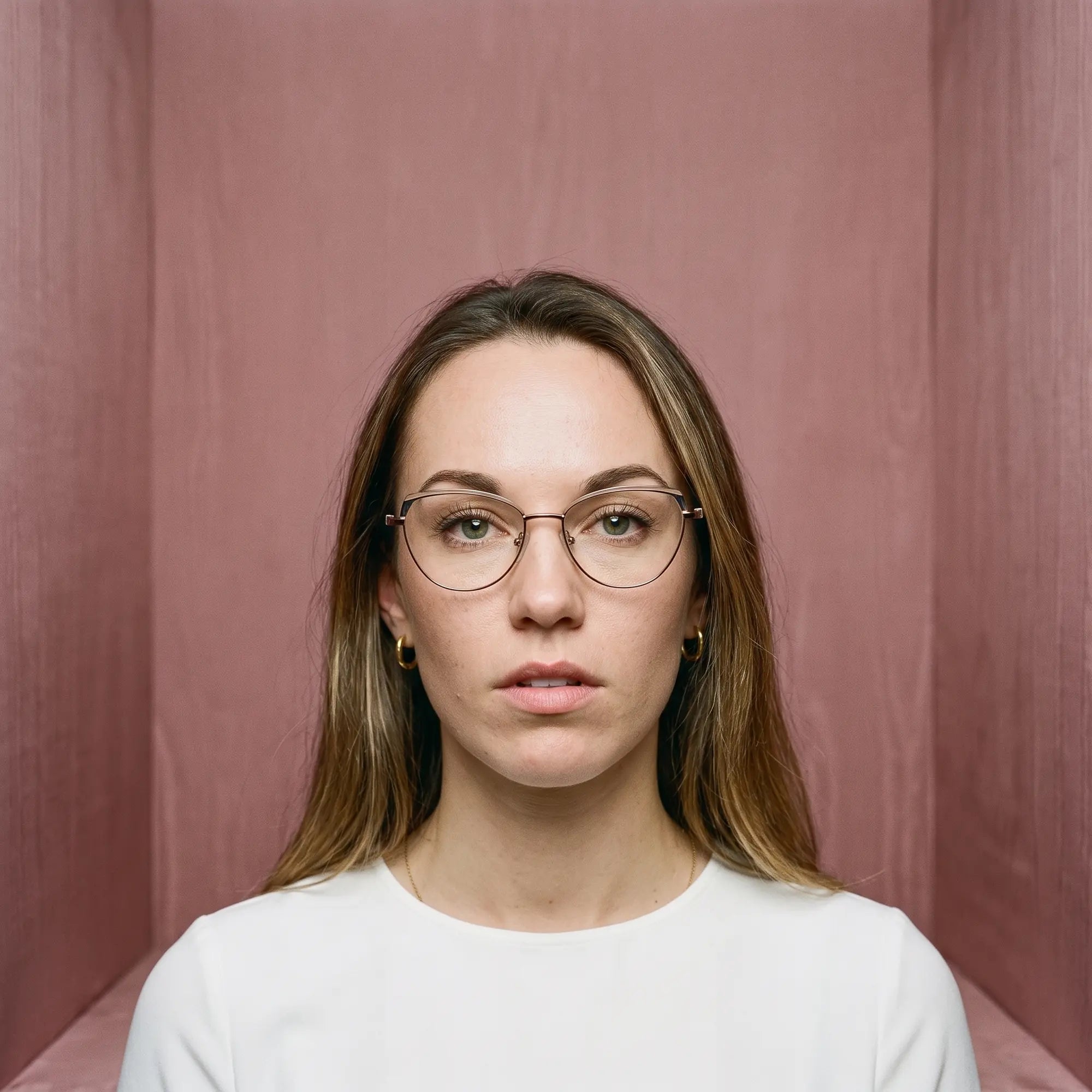 Fiore 3983 eyeglasses in grey gun, worn by a model – campaign portrait, face framed by rose moire upholstery