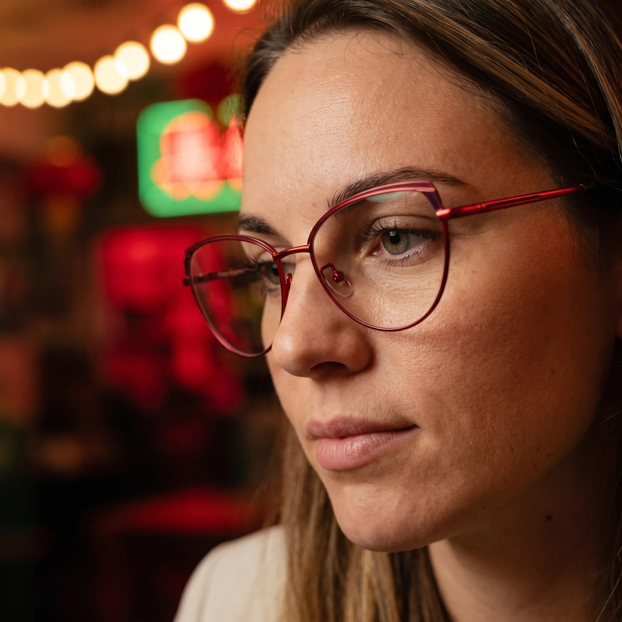 Fiore 3983 eyeglasses in red black, worn by a model – campaign portrait, candid portrait in neon-lit evening glow