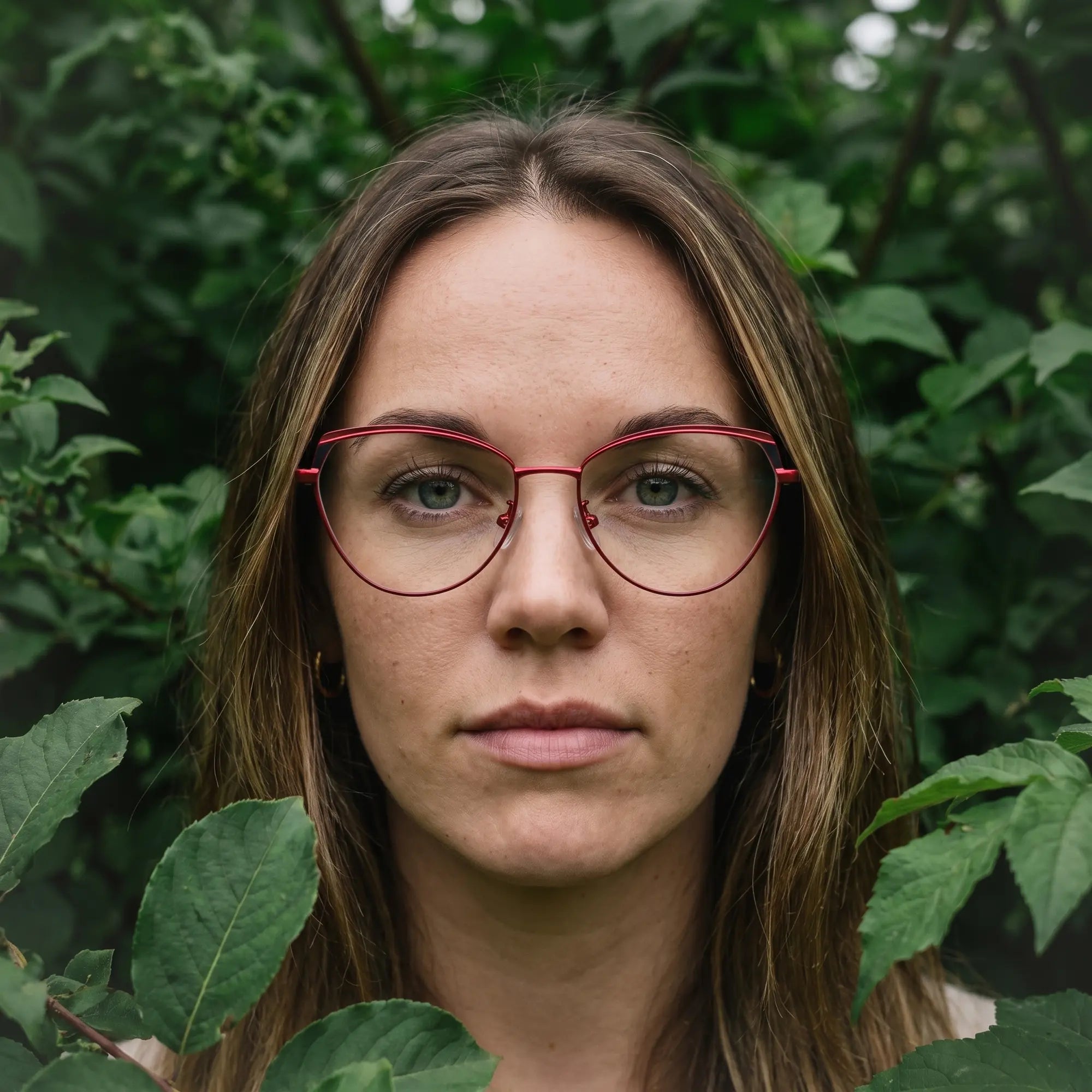 Fiore 3983 eyeglasses in red black, worn by a model – campaign portrait, summer daydream in a garden armchair