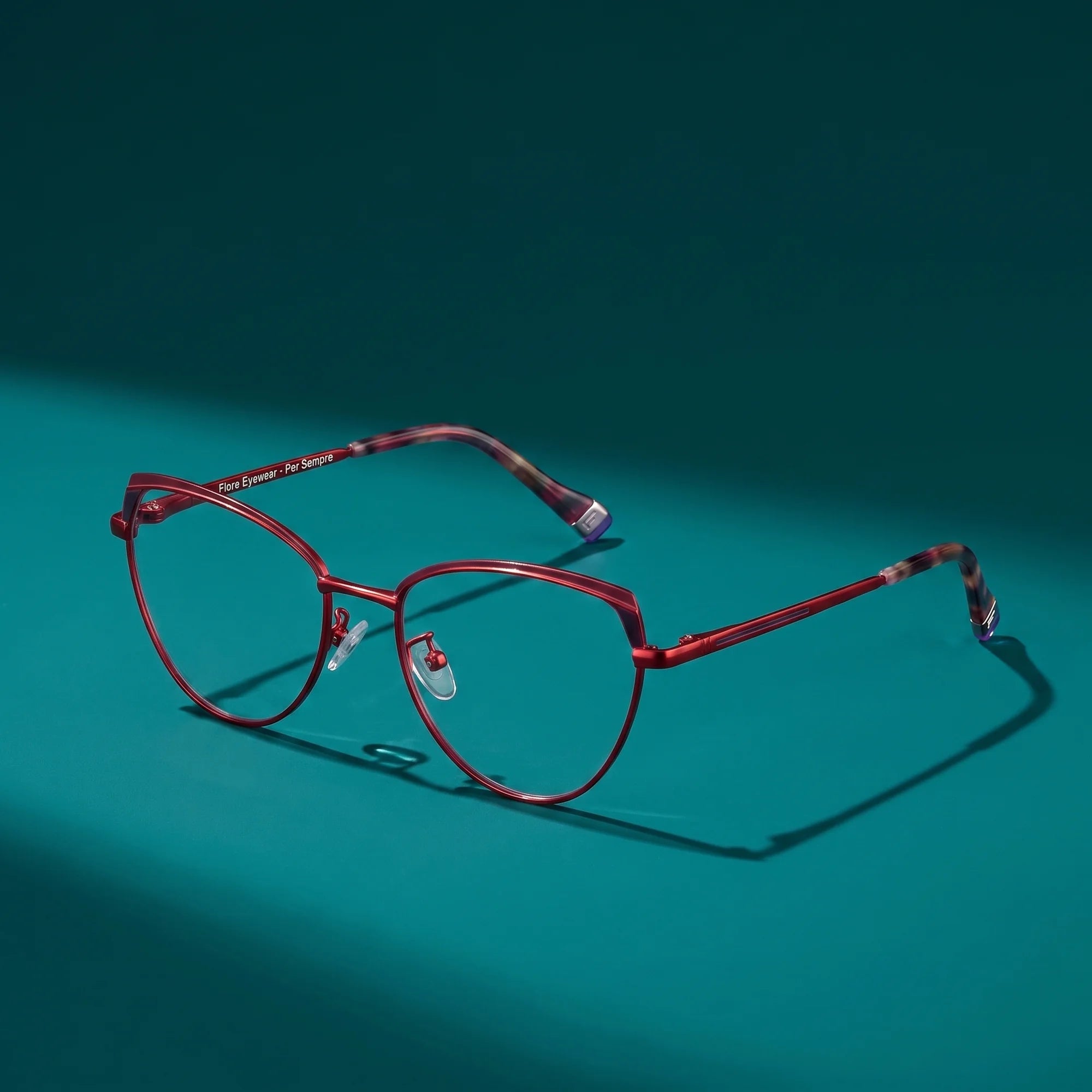 Fiore 3983 eyeglasses in red black – hero still life against a deep teal backdrop