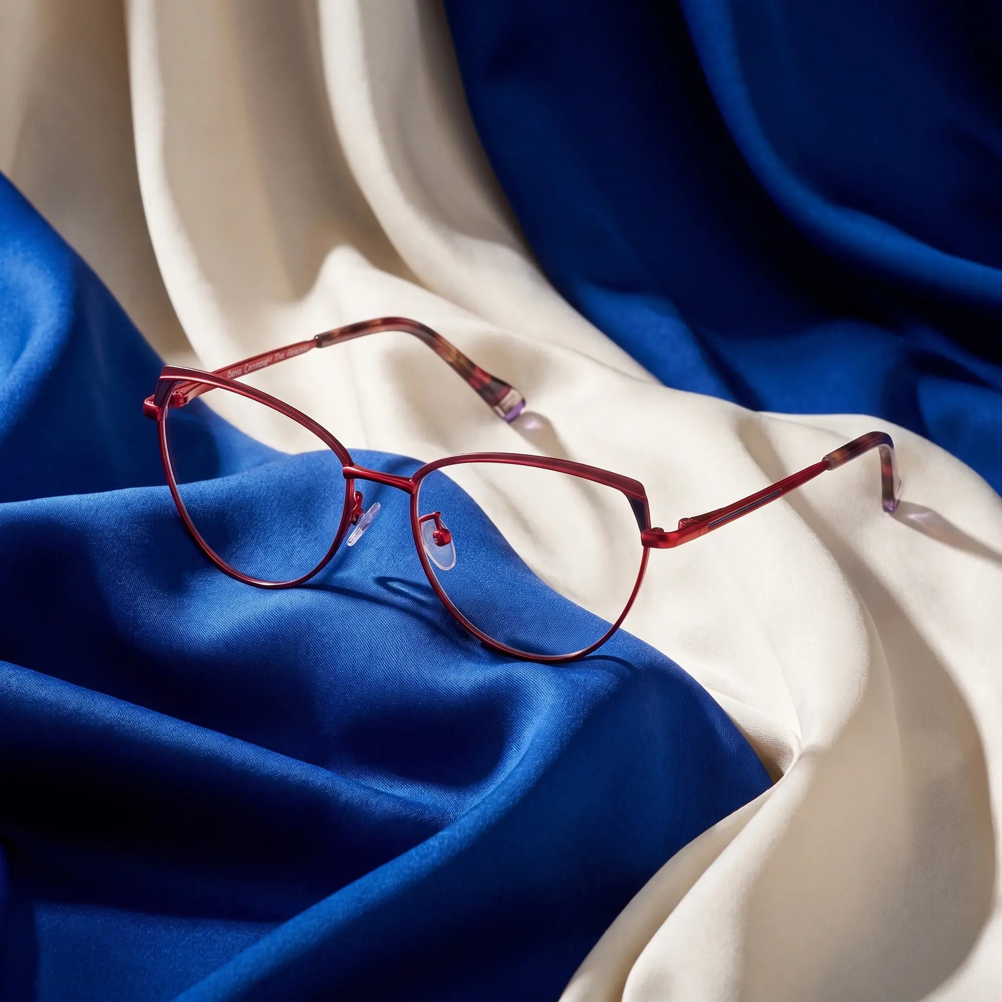 Fiore 3983 eyeglasses in red black – resting on draped cobalt and ivory silk