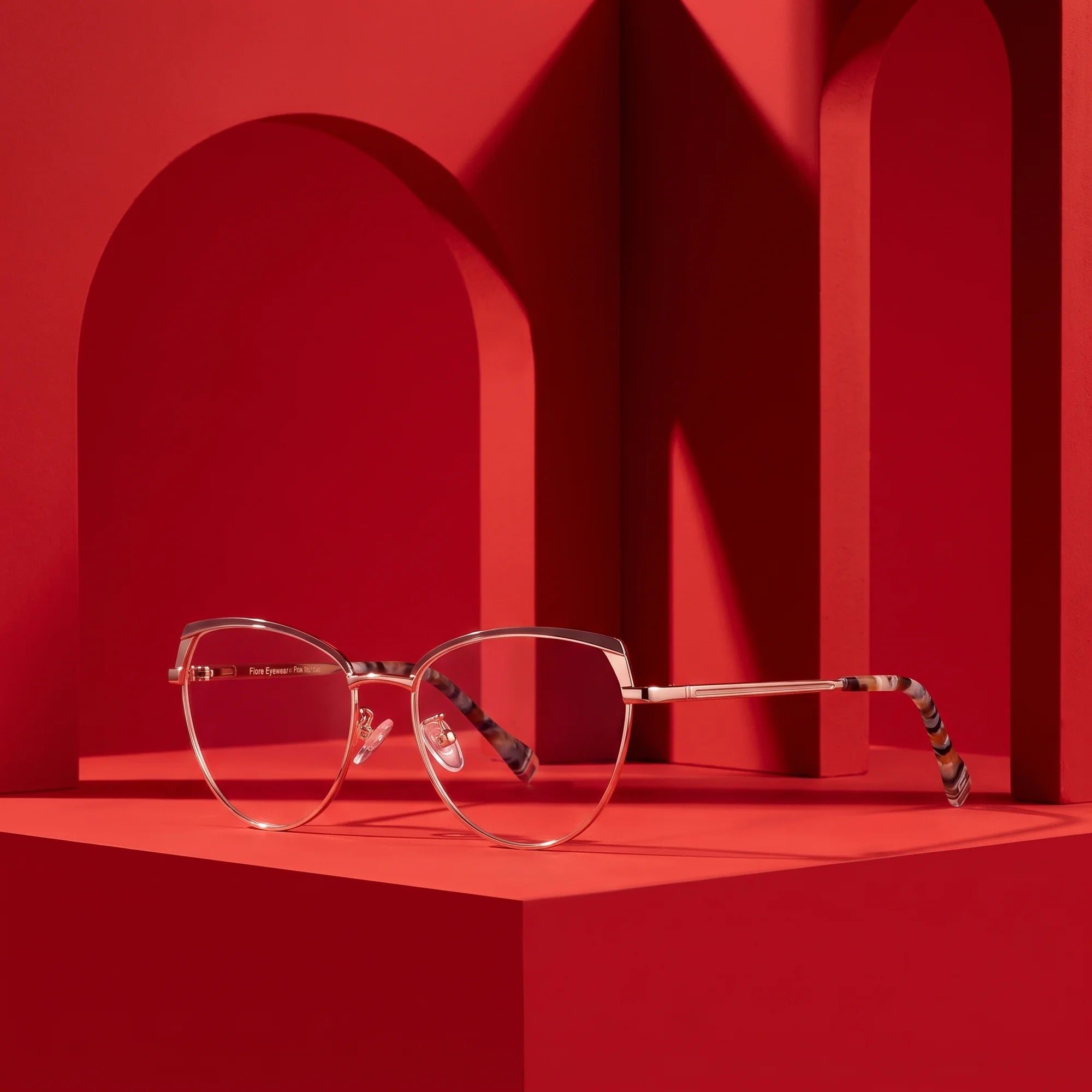 Fiore 3983 eyeglasses in brown gold – staged on a sculptural vivid red architecture set