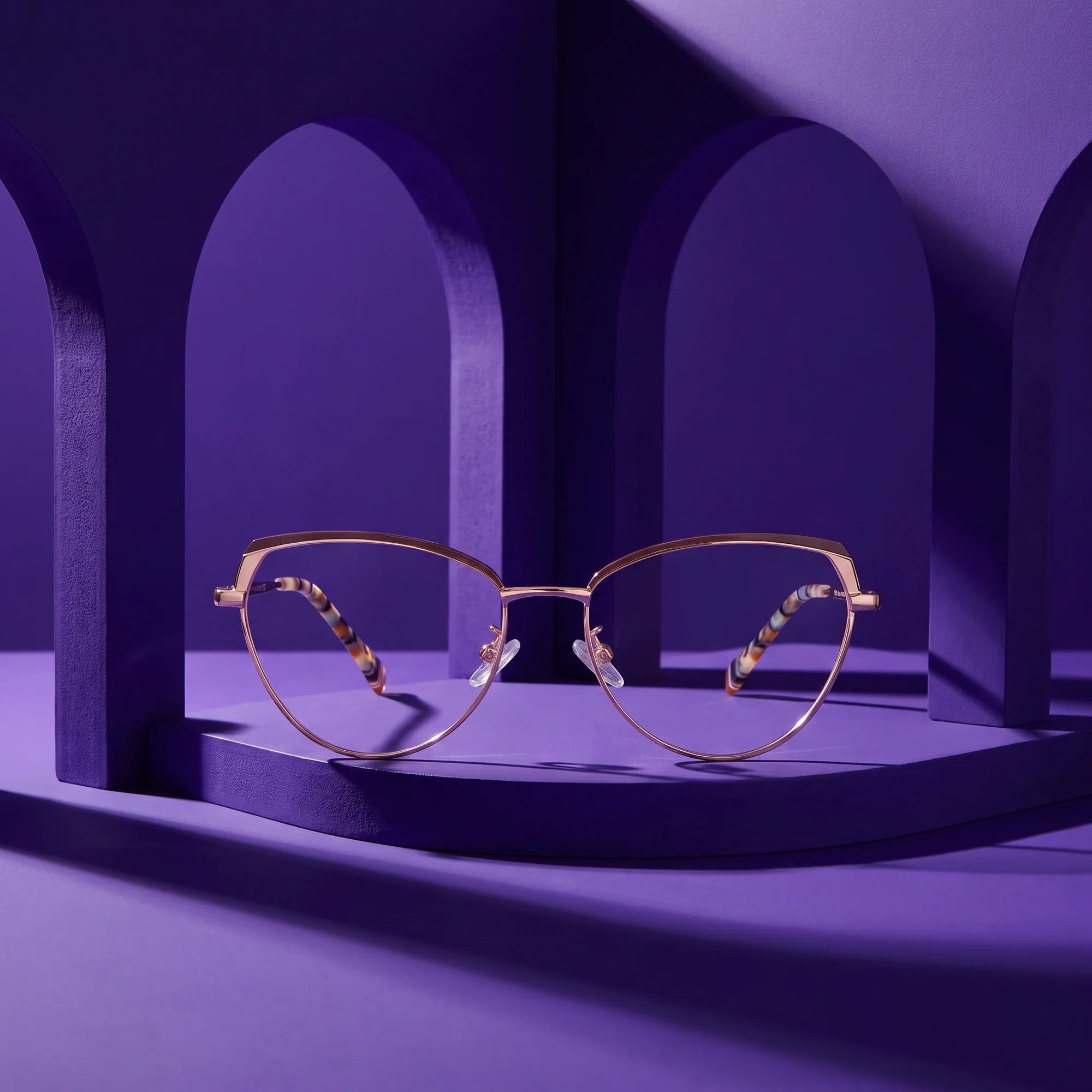 Fiore 3983 eyeglasses in brown gold – displayed on a violet podium among arches