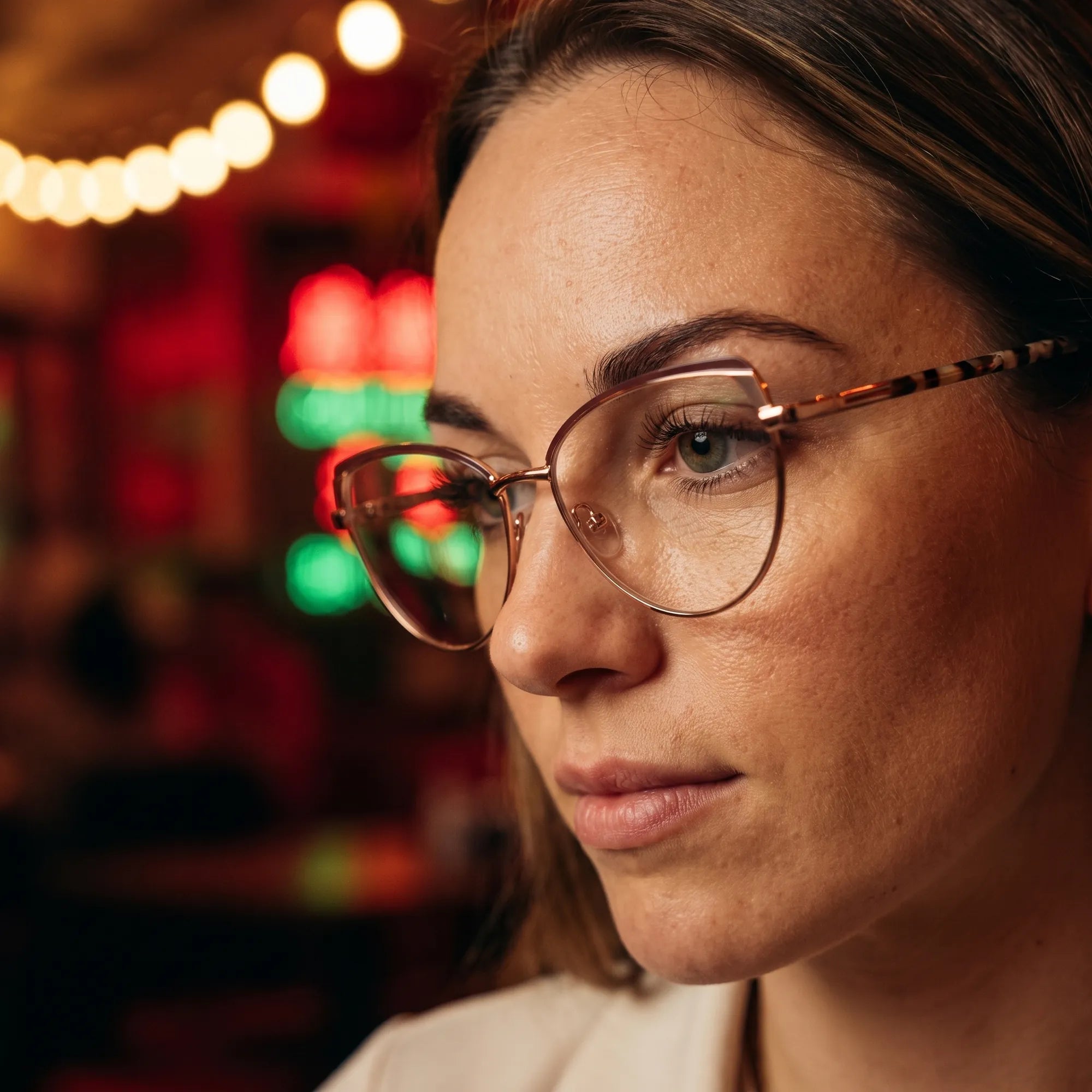 Fiore 3983 eyeglasses in brown gold, worn by a model – campaign portrait, candid portrait in neon-lit evening glow
