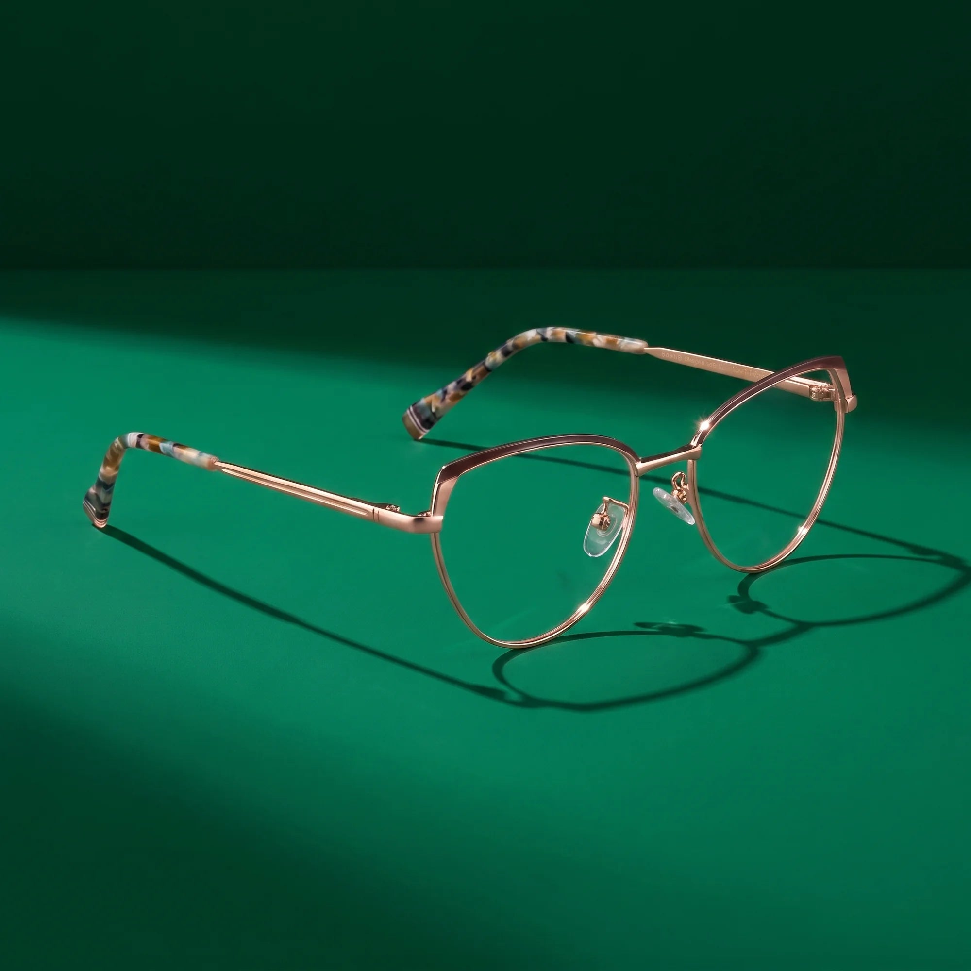 Fiore 3983 eyeglasses in brown gold – editorial still life on a saturated emerald set