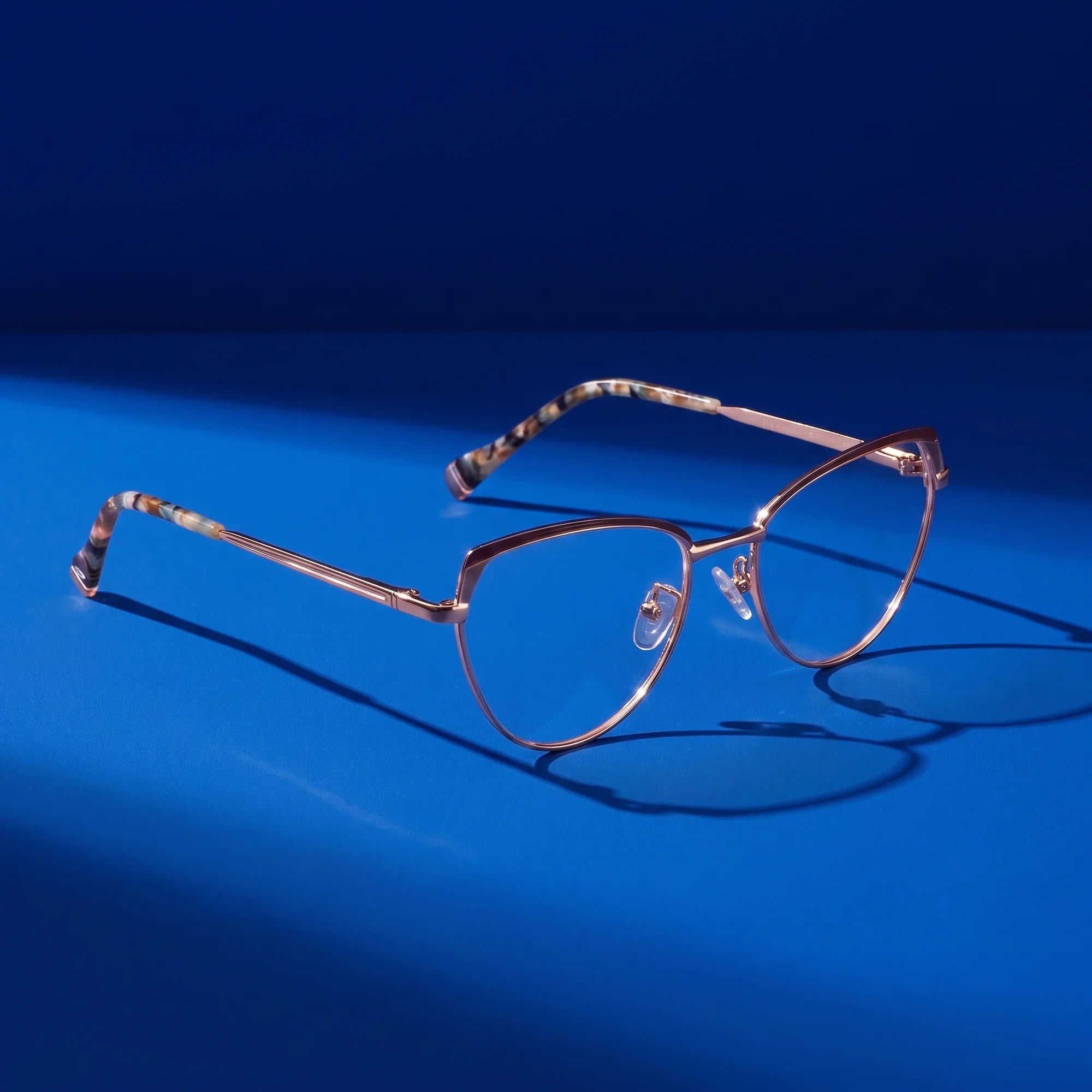 Fiore 3983 eyeglasses in brown gold – still life on a seamless cobalt studio backdrop