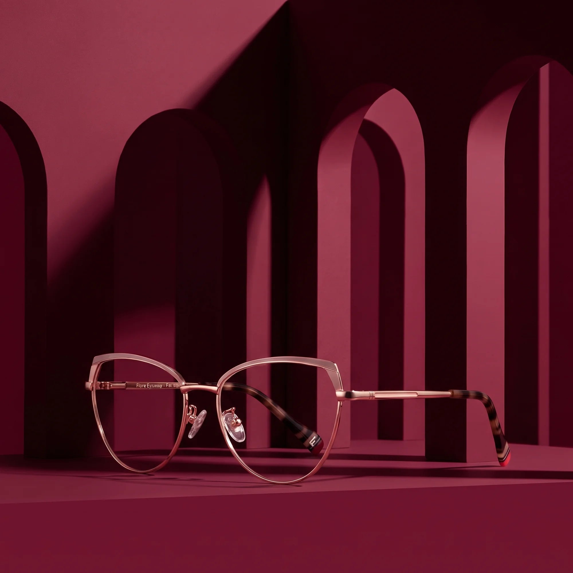 Fiore 3983 eyeglasses in pink gold – displayed on a burgundy podium among arches