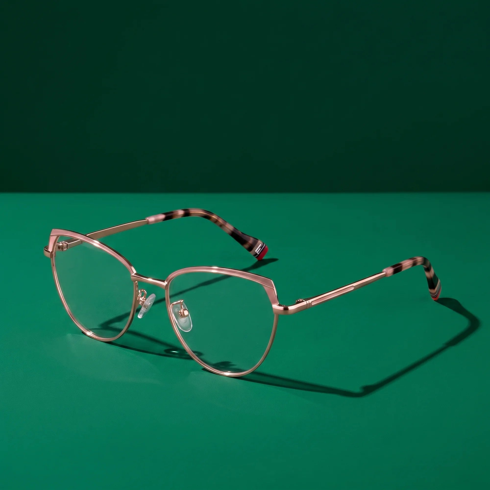 Fiore 3983 eyeglasses in pink gold – editorial still life on a saturated emerald set