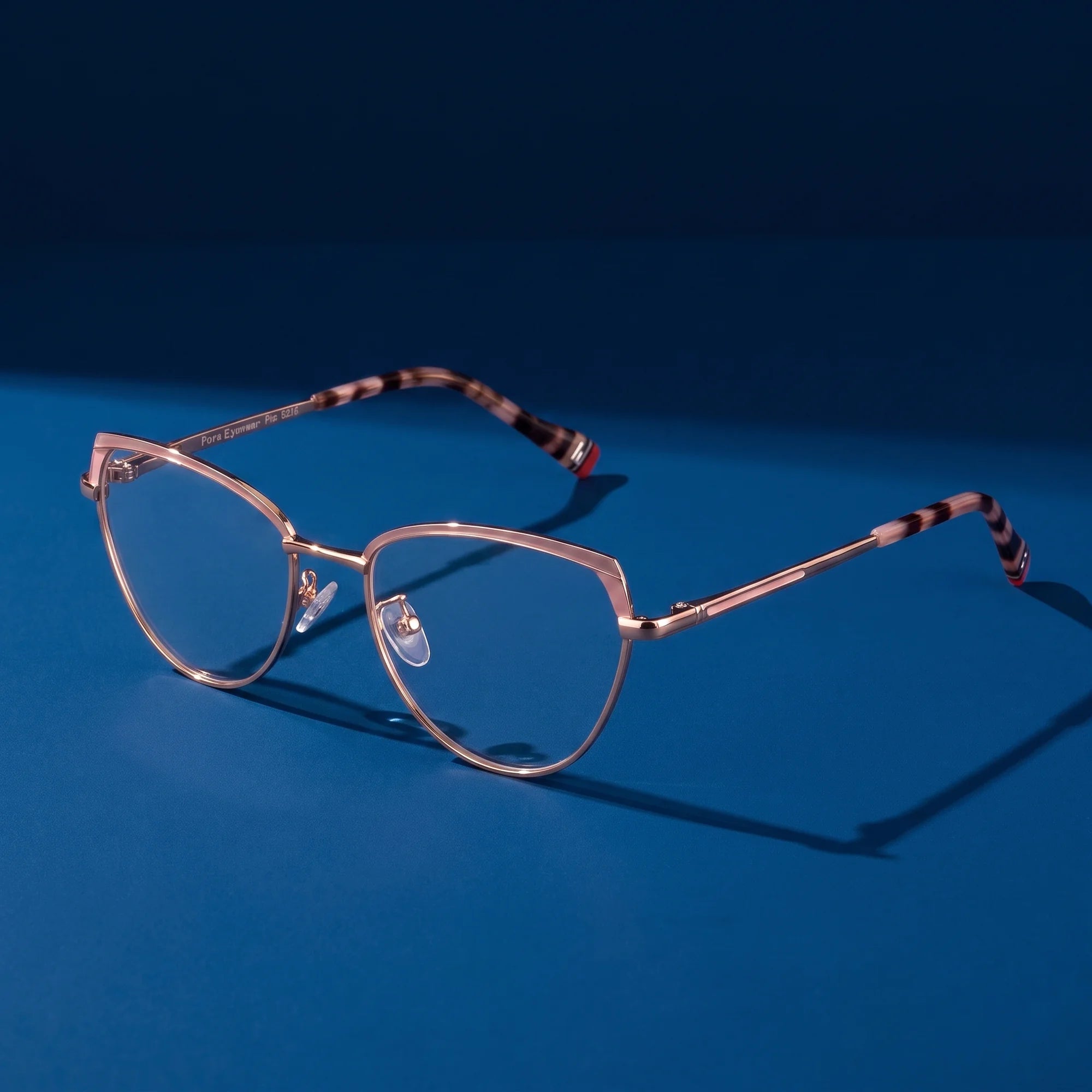 Fiore 3983 eyeglasses in pink gold – hero still life against a deep midnight blue backdrop