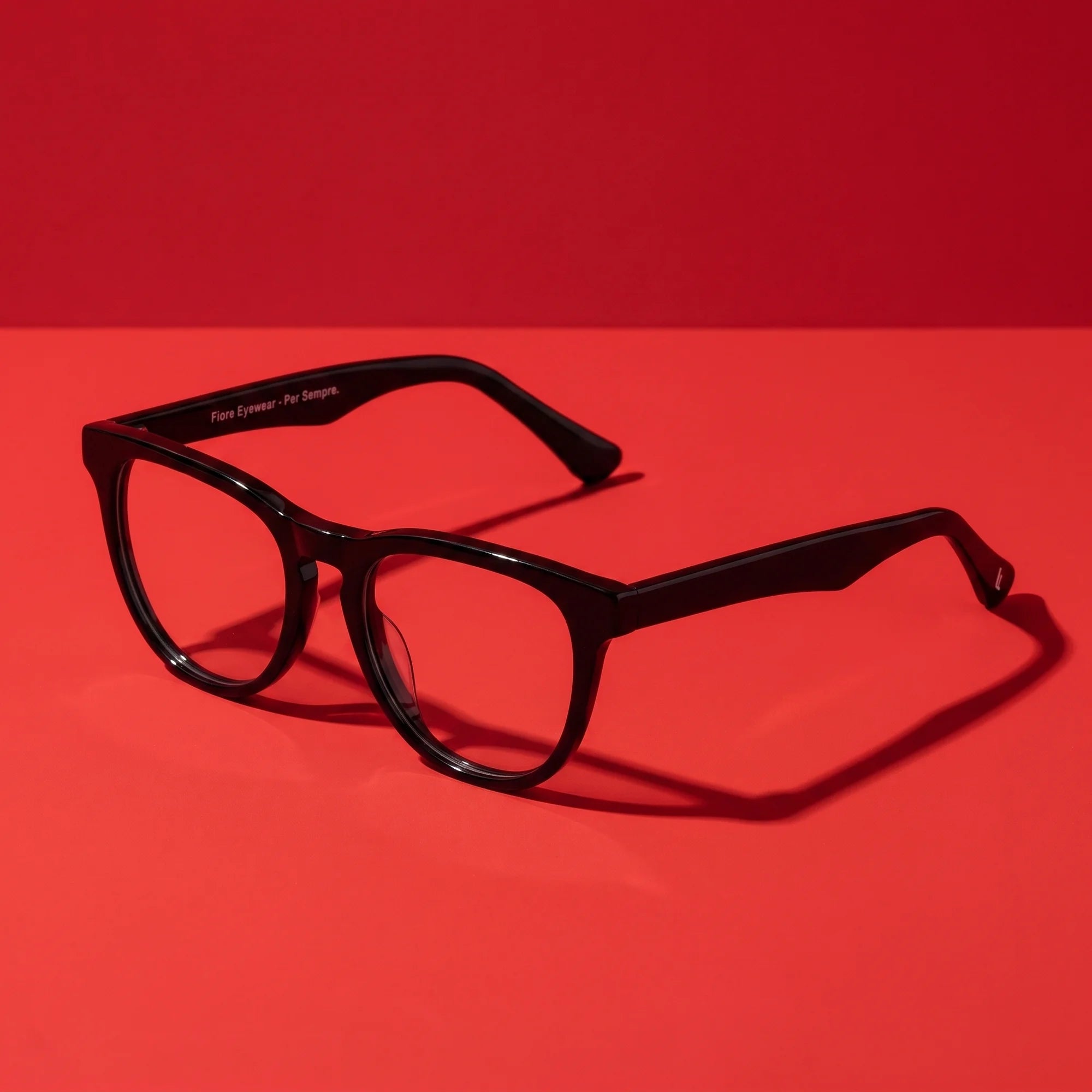 Fiore 4488 eyeglasses in black – editorial still life on a saturated vivid red set