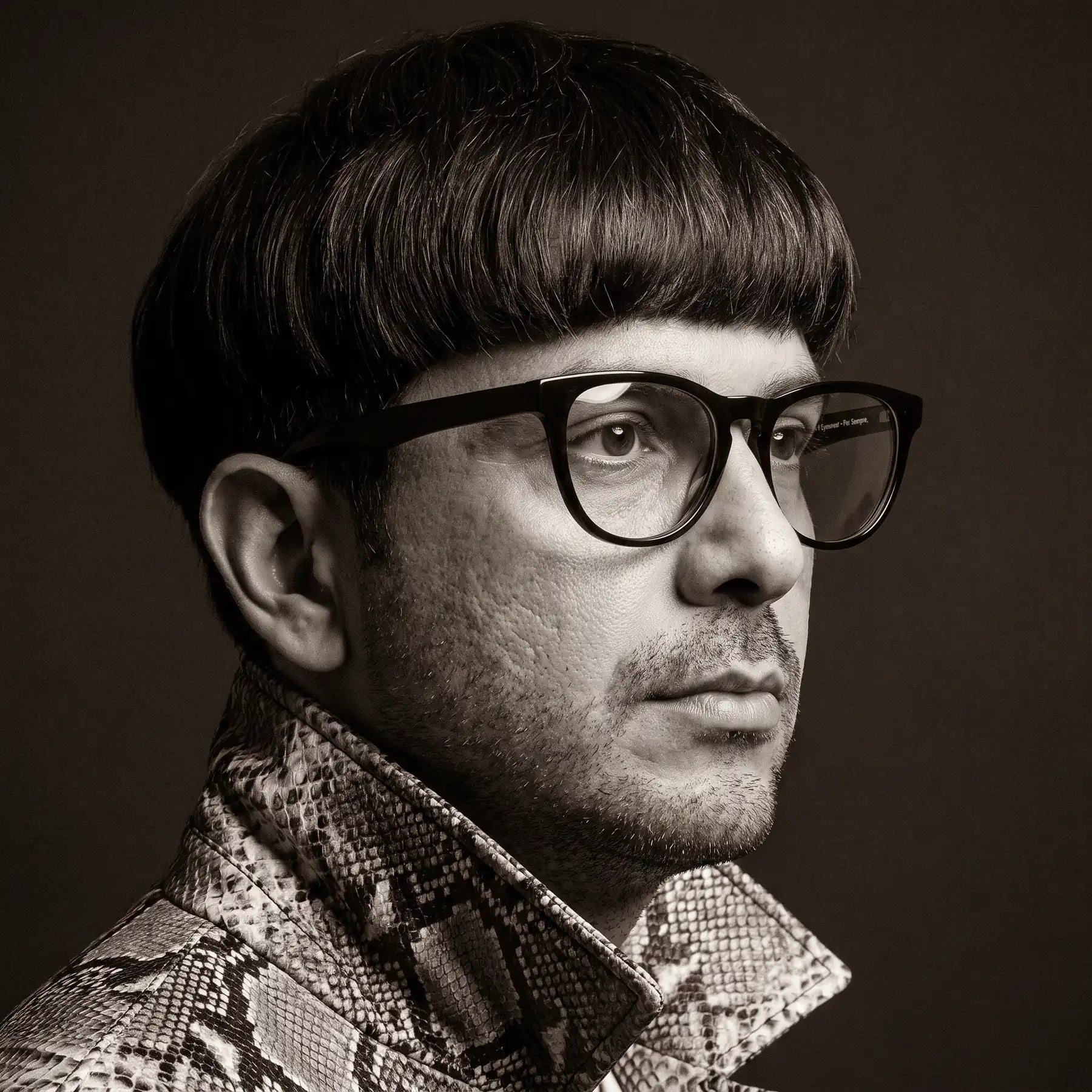 Fiore 4488 eyeglasses in black, worn by a model – campaign portrait, monochrome studio portrait, red graphic accents
