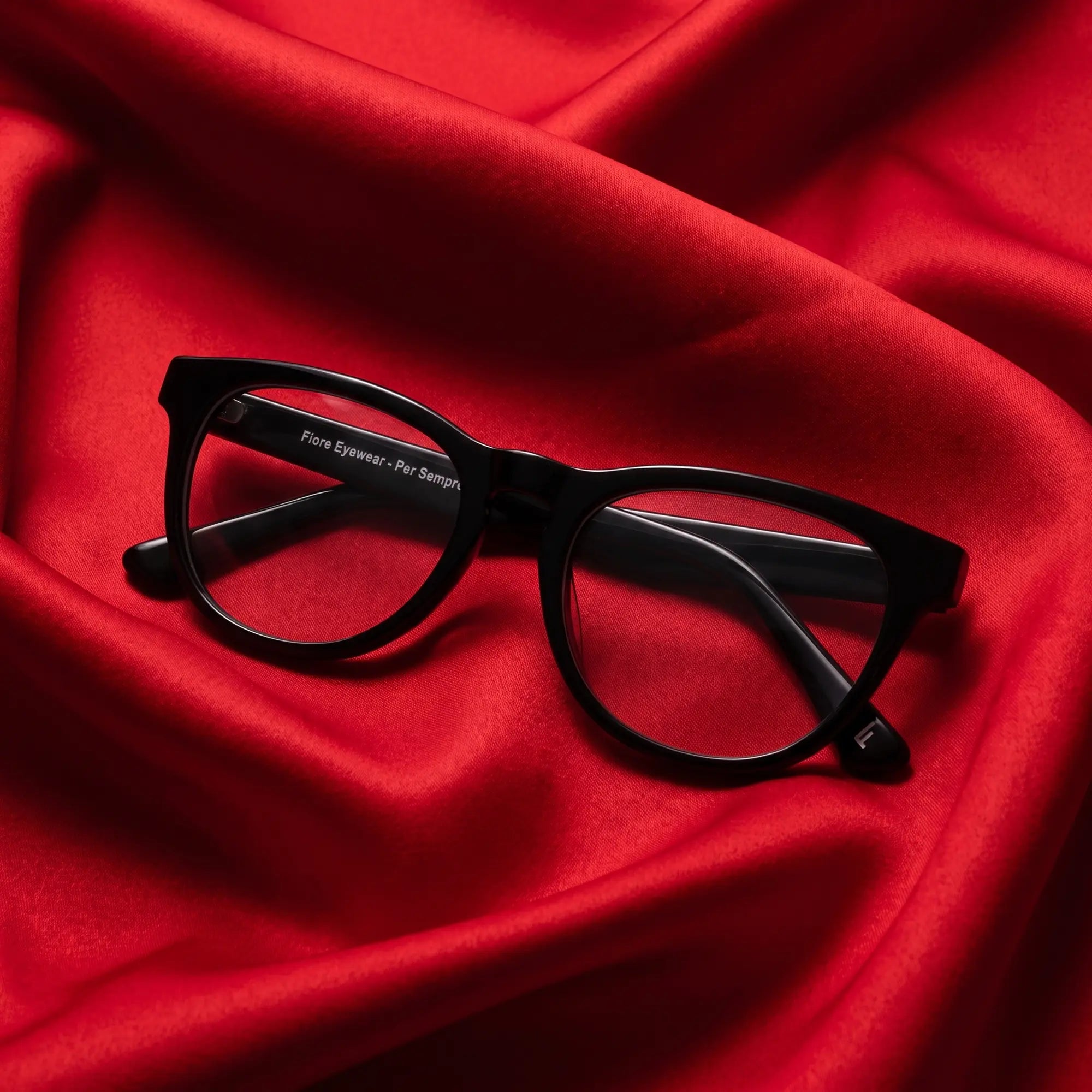 Fiore 4488 eyeglasses in black – nested in flowing vivid red silk