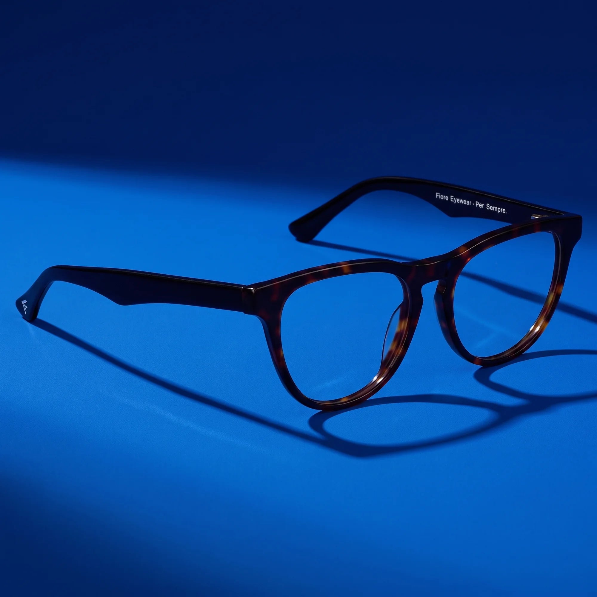 Fiore 4488 eyeglasses in tortoiseshell – hero still life against a deep cobalt backdrop