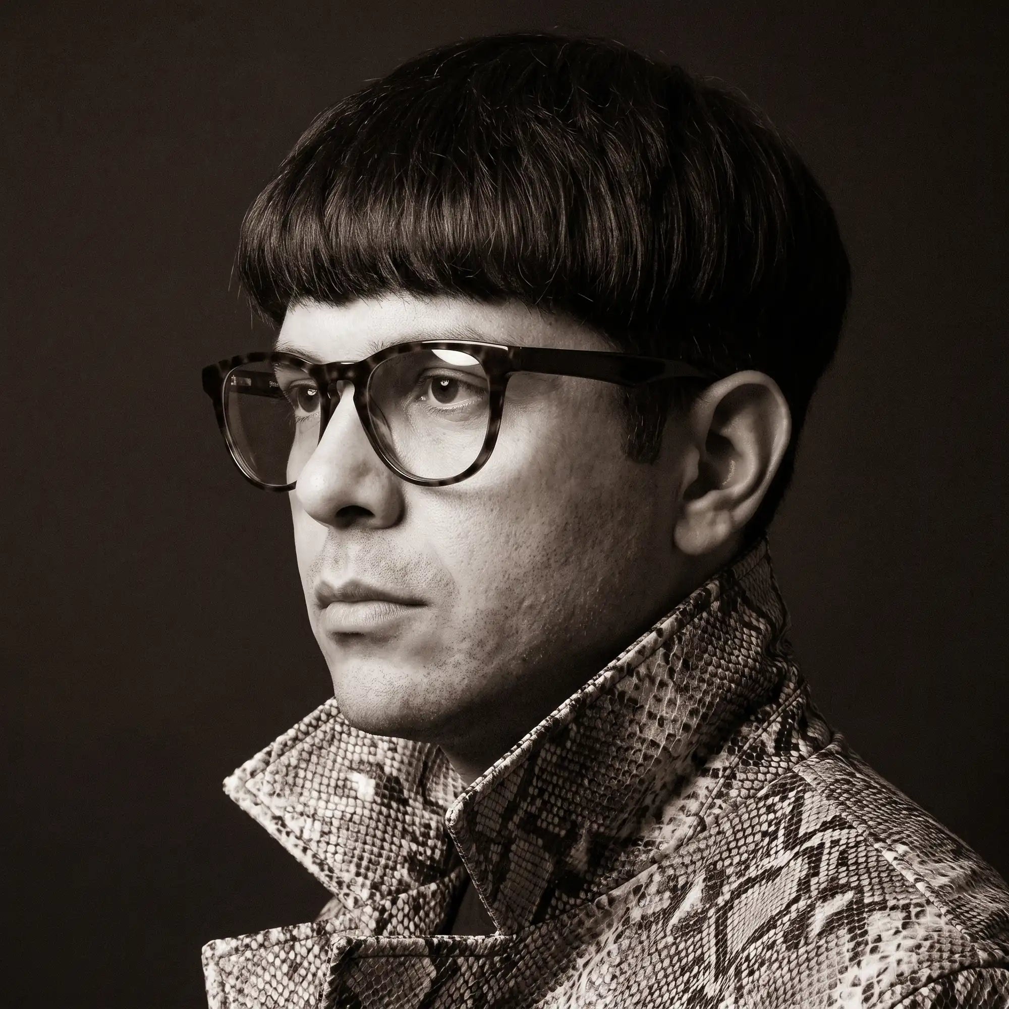 Fiore 4488 eyeglasses in tortoiseshell, worn by a model – campaign portrait, monochrome studio portrait, red graphic accents