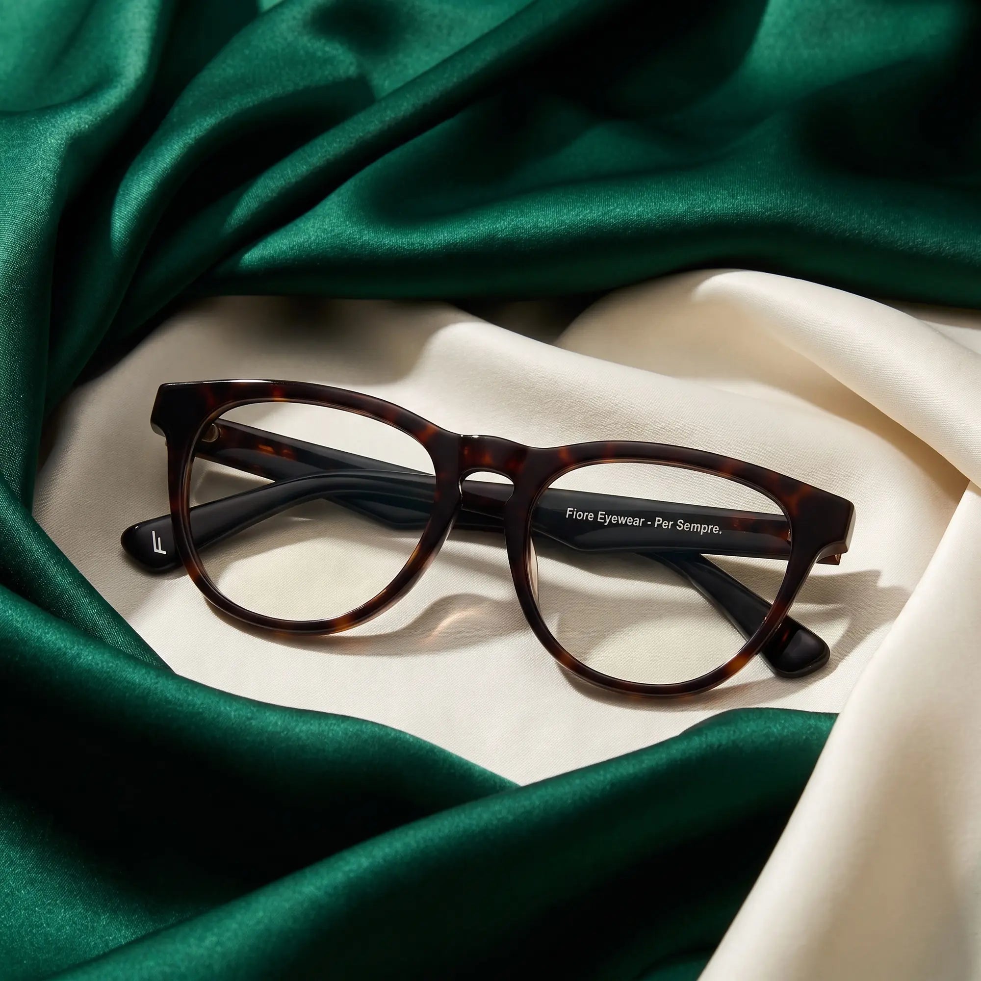 Fiore 4488 eyeglasses in tortoiseshell – resting on draped emerald and ivory silk