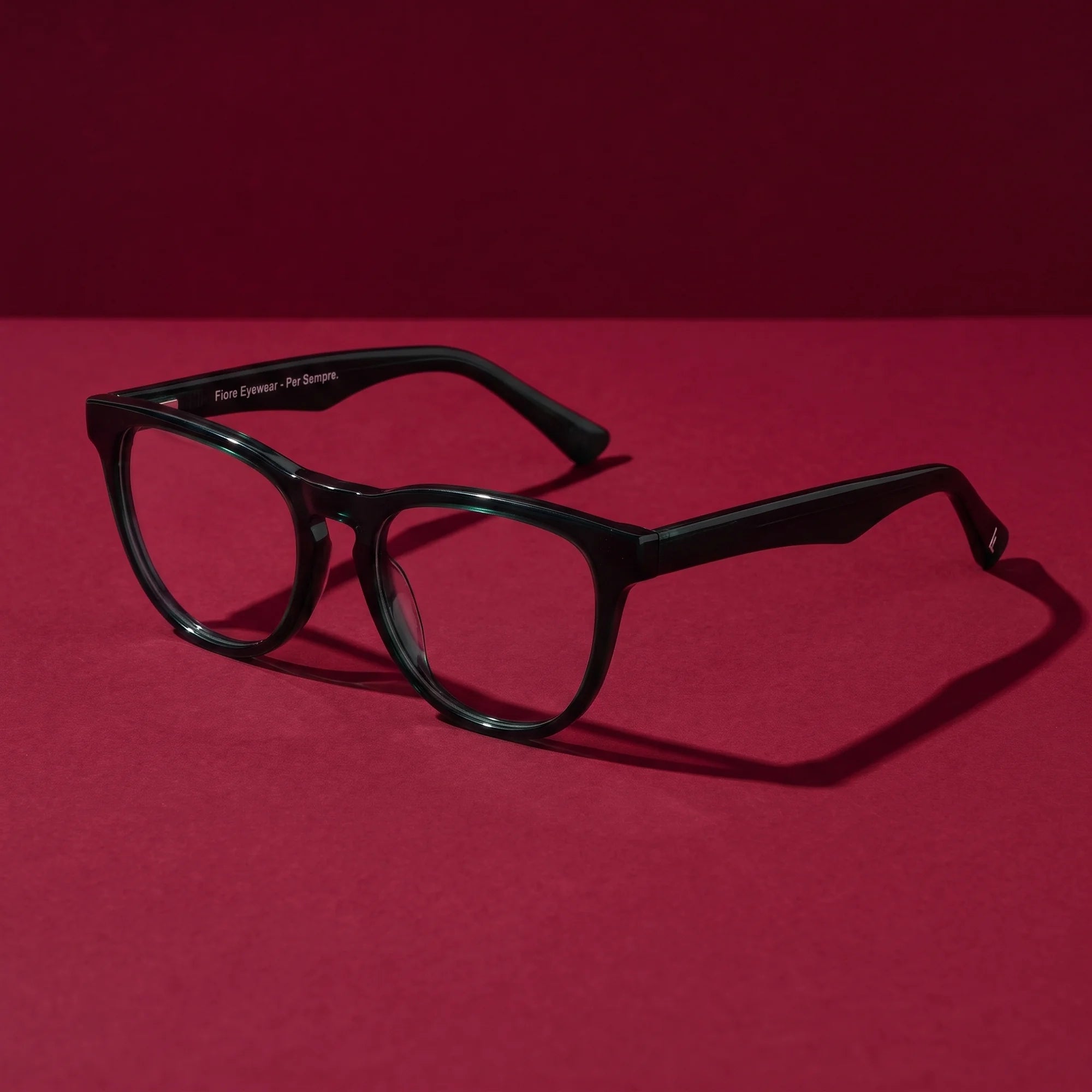 Fiore 4488 eyeglasses in green – editorial still life on a saturated burgundy set