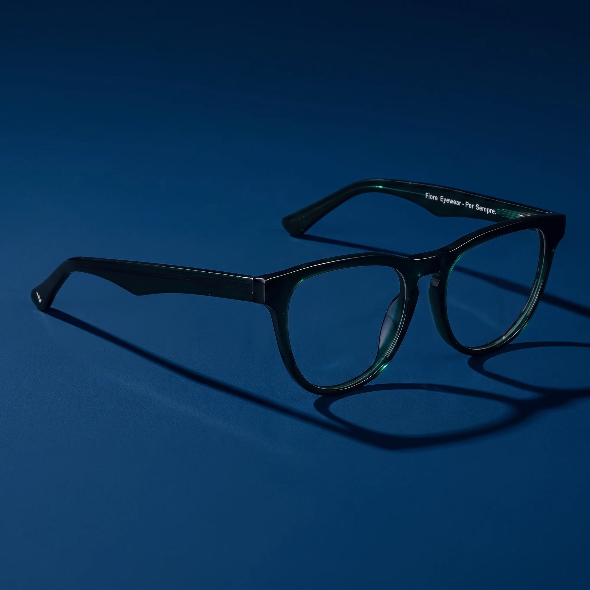 Fiore 4488 eyeglasses in green – hero still life against a deep midnight blue backdrop