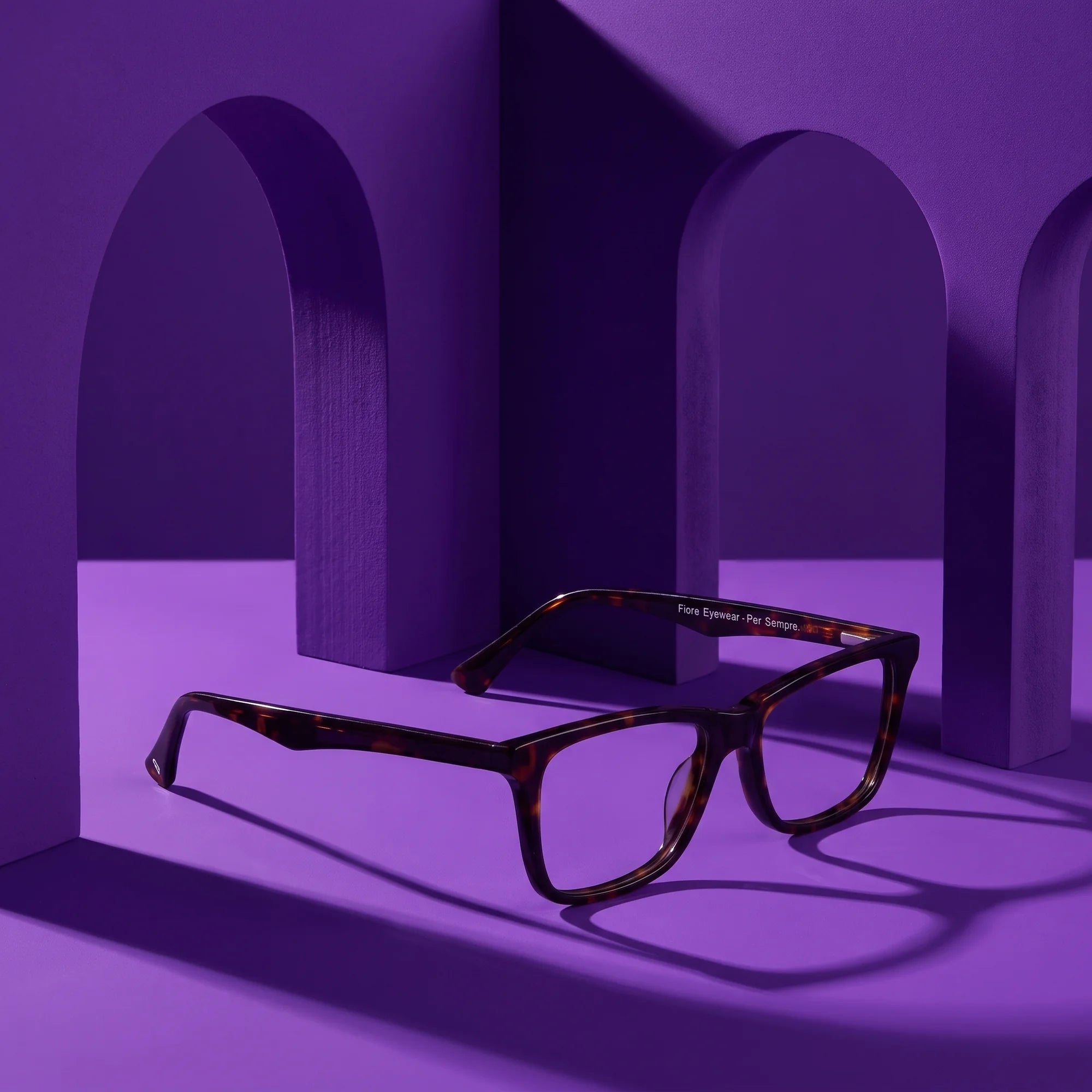 Fiore 5228 eyeglasses in tortoiseshell – displayed on a violet podium among arches